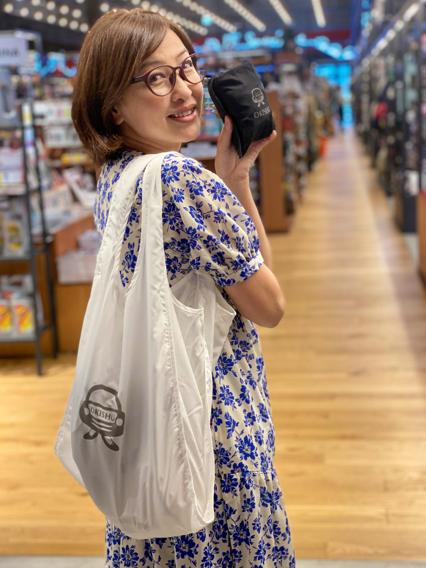 私がクルマ業界のオシャレ番長と呼んでいる吉田由美さんに、本業の1つでもあるモデルを依頼（笑）。毎日の買い物にちょうどいい、容量27Lのドライブエコバッグは、シューズバッグにもなります。軽くて水濡れにも強いリサイクルポリエステル素材で、小さく折りたためるパッカブル仕様。使っても畳んでもリフレクタープリントが出るようになっています。色はホワイトとブラックがありますよ