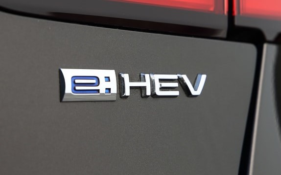 e：HEVは、電動化コア技術である高効率・低燃費な2モーターハイブリッドシステムのグローバル統一呼称で、「e」には「electric（電気）をenergy（原動力）にして、みんなの笑顔と元気を力強くenergize（活気づける）していく」という意味が込められている