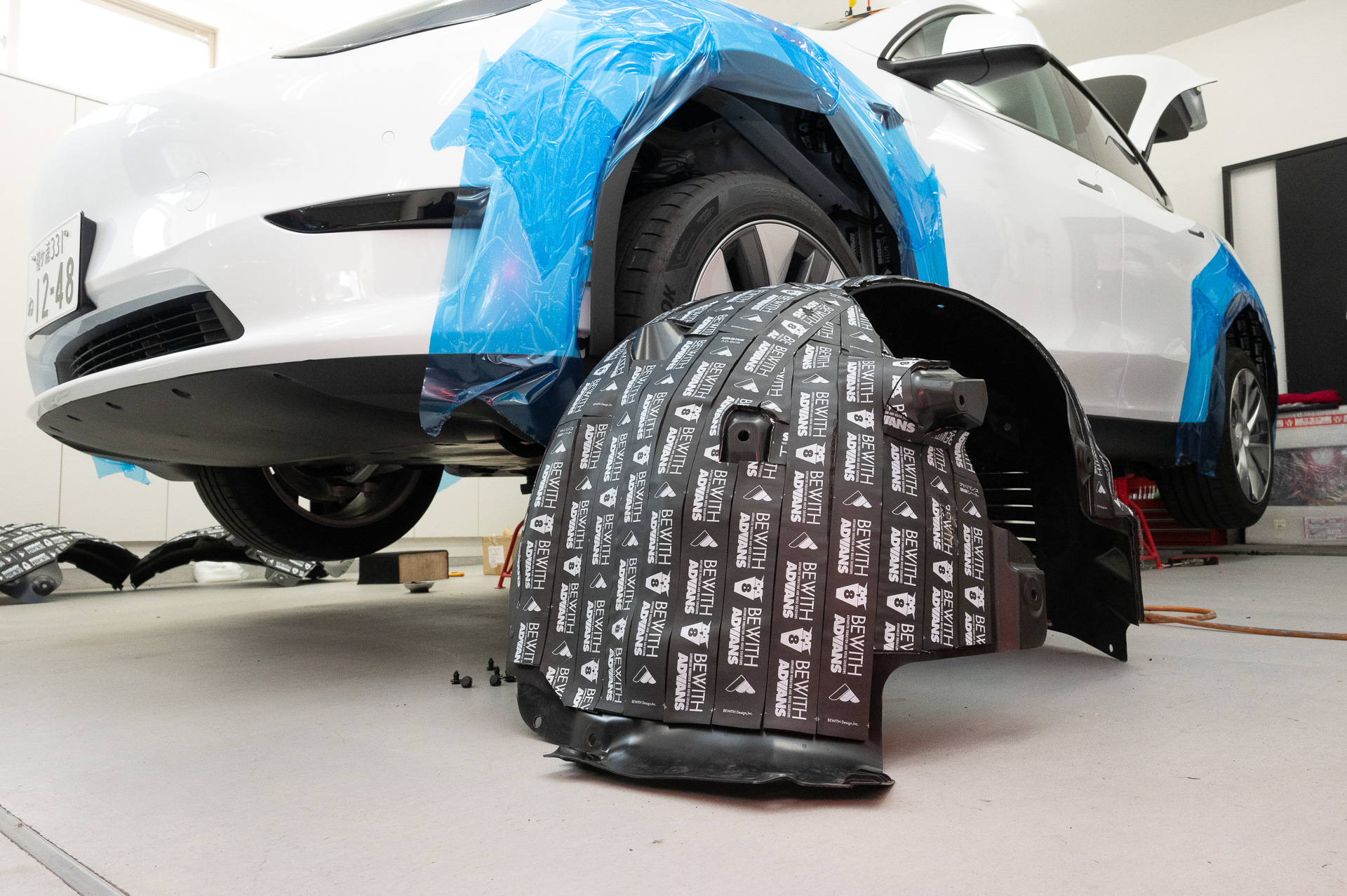 まずはフロント。ホイールハウス内側にあるインナーフェンダーを外し、糊がしっかりと付くように洗浄。そして音が侵入しないよう、すき間なくアドバンス調音シートをインナーフェンダーに張り付けていく