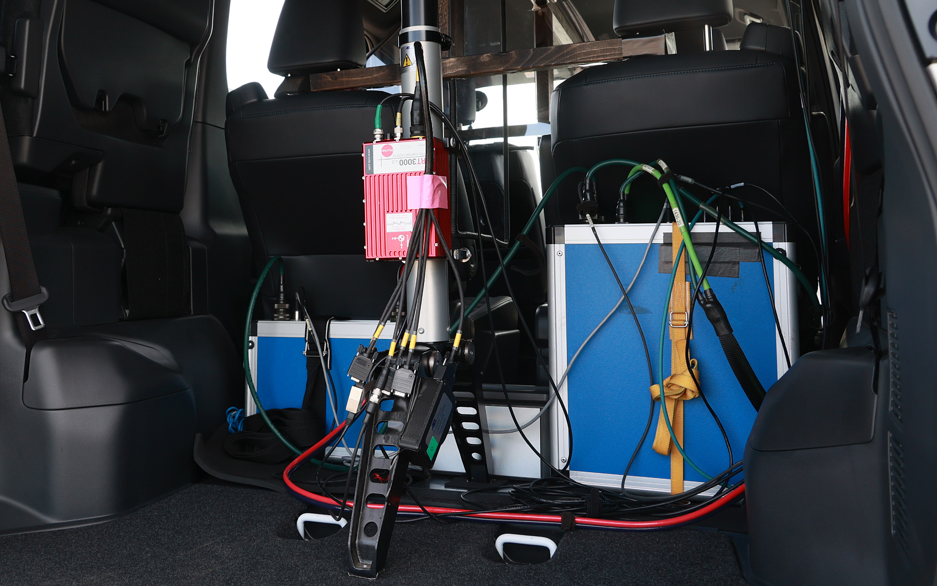 ラゲッジの様子。ロボット制御用の装置とバッテリ、そしてGPS計測機器が搭載されている。電源は車両側からも取るが、試験中はデータの安定化のために試験機用の電源のみから給電される。ロボットの動作には60Vほど必要