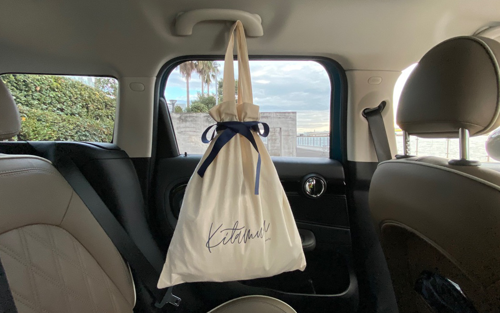 横浜元町キタムラさんの新しい筆記体のロゴと、リボンがとっても素敵な衣装バッグ。MINIのリアドア上にあるフックに引っ掛けると、すごく使いやすくて重宝しています