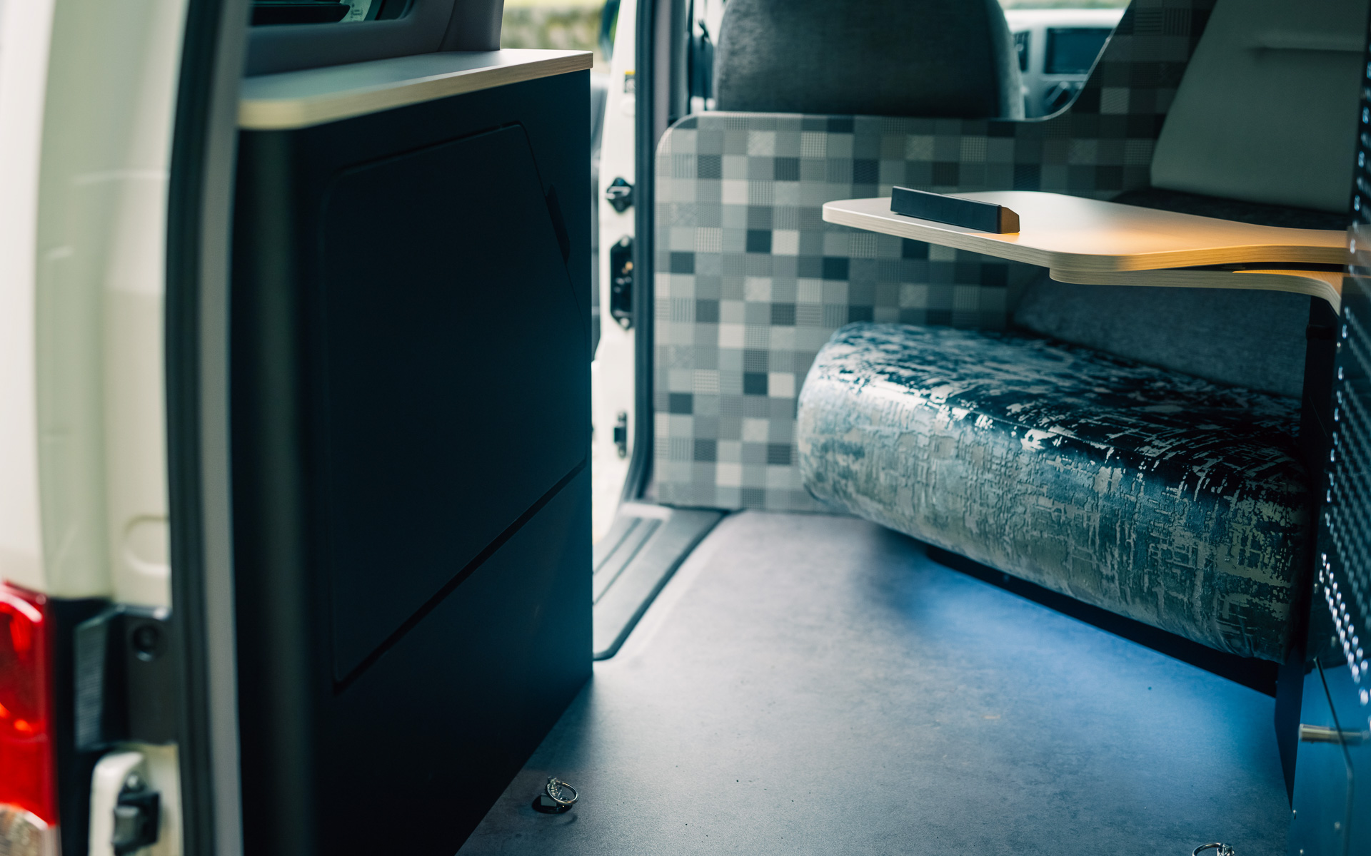 タイヤハウスを生かしたサイドテーブルには、足を乗せることができる格納式オットマンを収納している