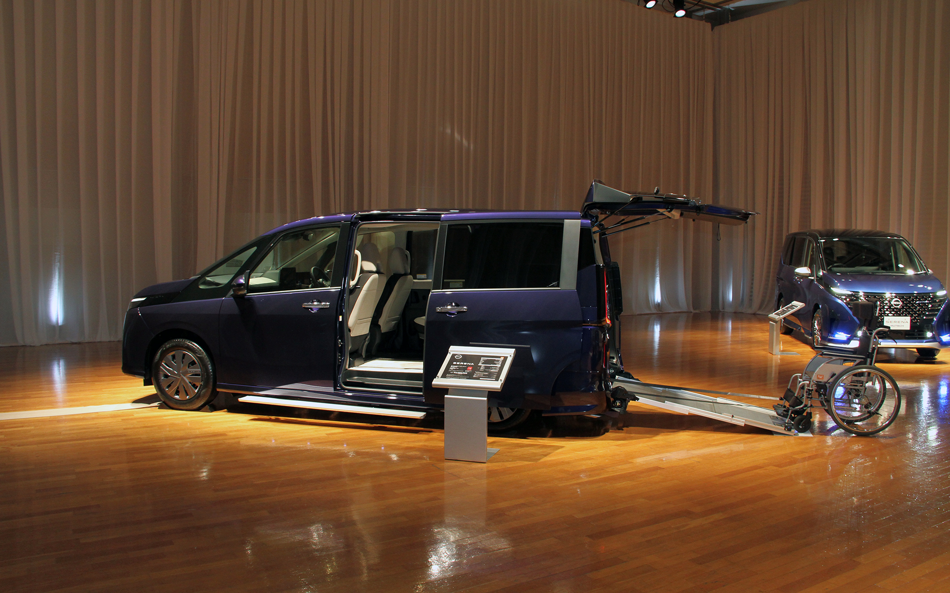 NMCのチェアキャブ スロープタイプ（Xベースの車いす2名仕様/350万8000円）。バックドアから車いすのまま車内に乗り込めるよう、手動式のスロープや車いす乗降アシスト装置（電動ウインチ）、車いす固定装置（電動式）を装備