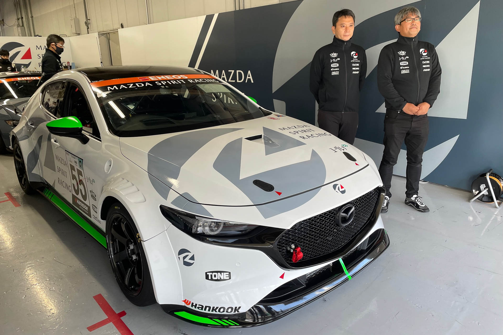 出撃前のMazda3。左はインタビューでエンジンを熱く語ってくれた上杉さん。右は車体について話してくれた楠（クス）さんでした