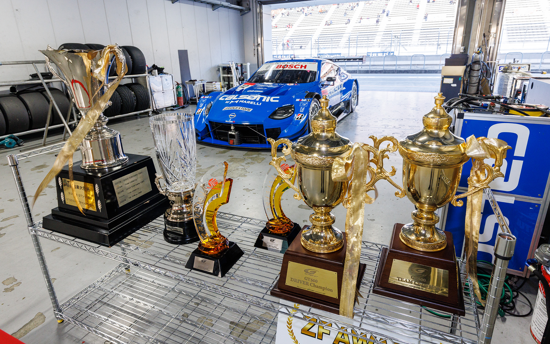 CALSONIC IMPUL Z（2022年SUPER GT GT500）。今年のチャンピオンマシンだけに数々のトロフィーも飾られていた