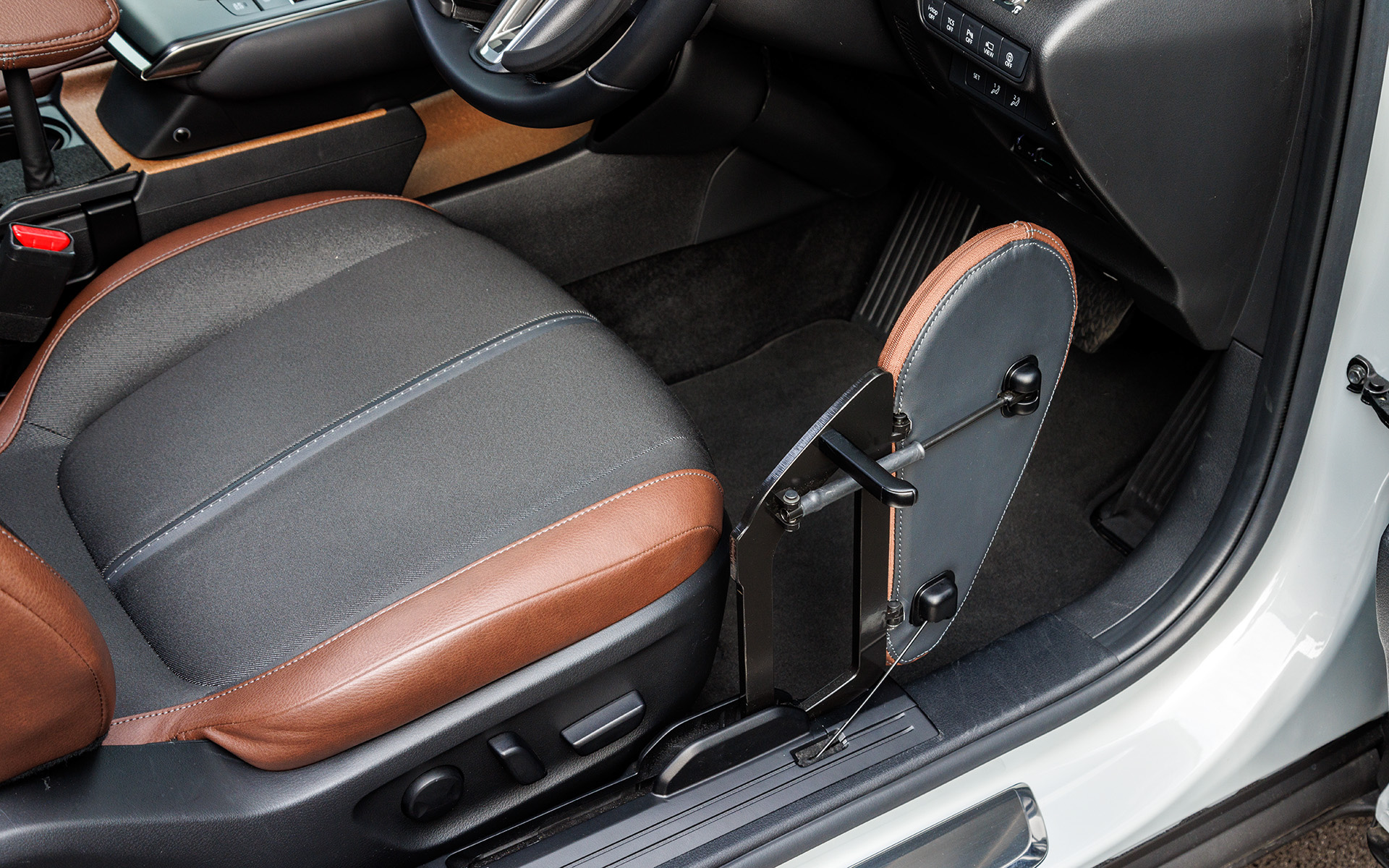 いちど運転席右側にある「移乗ボード」に乗り、その後シートへ移動する。走行中は「移乗ボード」は前にスライドし、右ひざのサポートとしても機能する