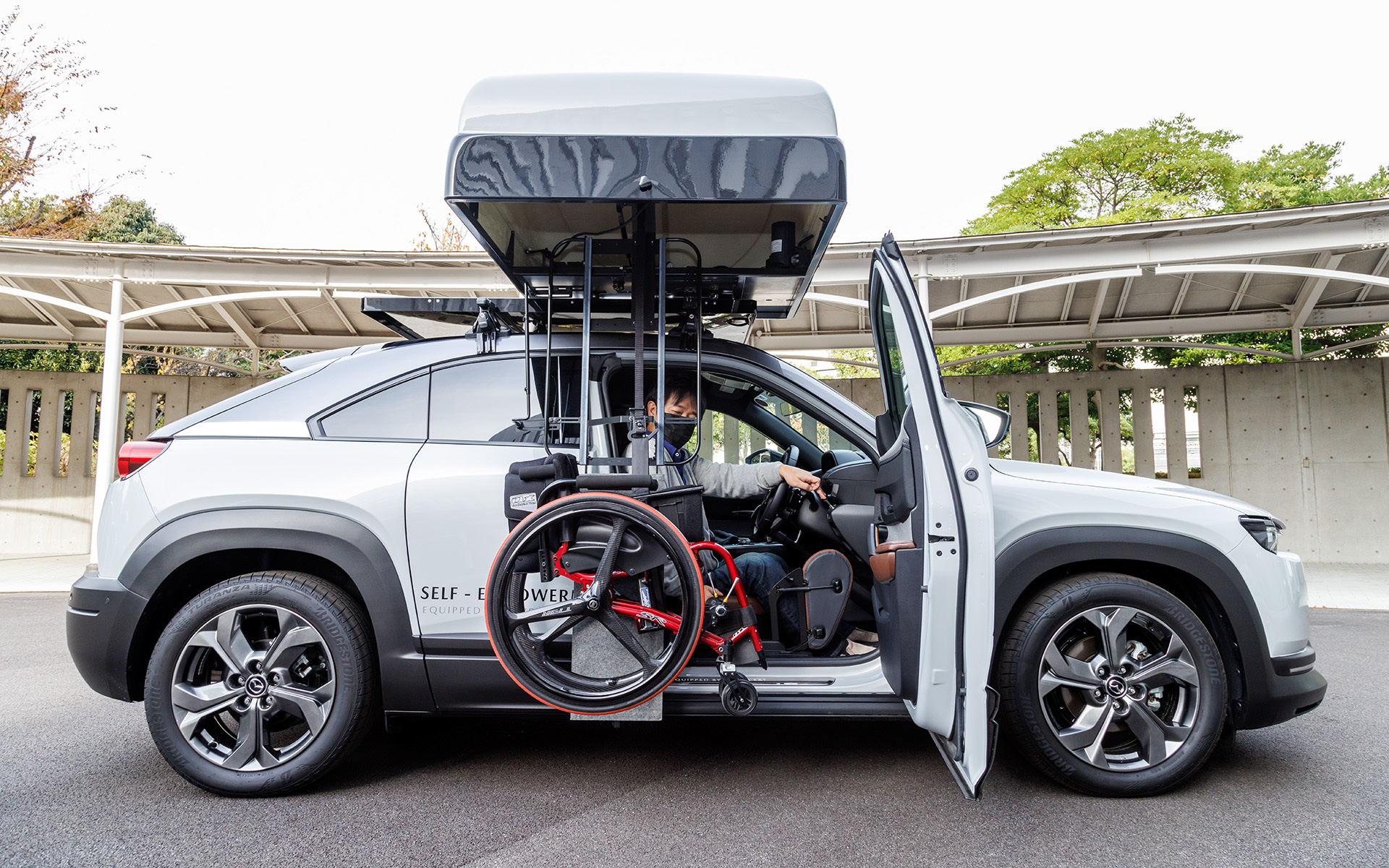 ルーフトランクに車いすを収納する「オートボックス」を使えば、頸椎損傷や半身マヒで上腕の力が弱いユーザーでもひとりで車いすの積み下ろしができる