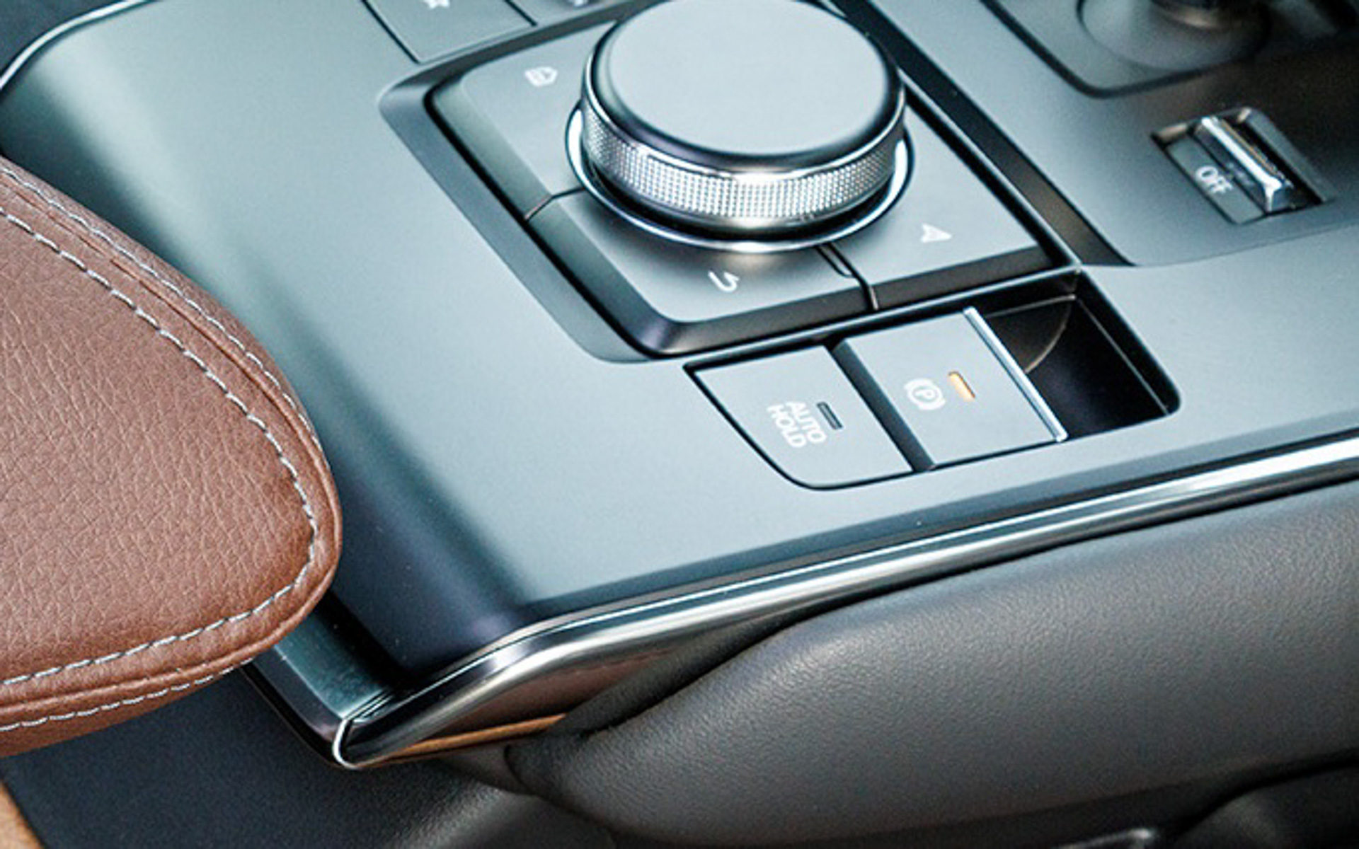 MX-30の標準装備であるブレーキホールド機能と組み合わせることで、ブレーキレバーやアクセルリングの使い勝手が各段に向上する！　スイッチ（AUTO HOLD）はセンターコンソールにある