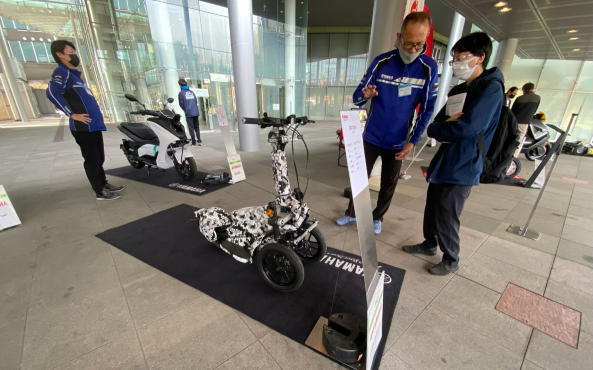 新企画の電動バイク展示で、あまりの可愛さに目が釘付けとなったのがコチラ。ヤマハが「転ばないバイク」として開発中のTRITOWNです。乗った人が自然に車体の中央に収まるハンドルやステップのレイアウトが特徴で、重量は約50kg。0〜25km/hまでの速度で制限設定も可能。走行可能距離は約30kmで、充電時間は約3.5時間となっています。発売が待ち遠しいですね