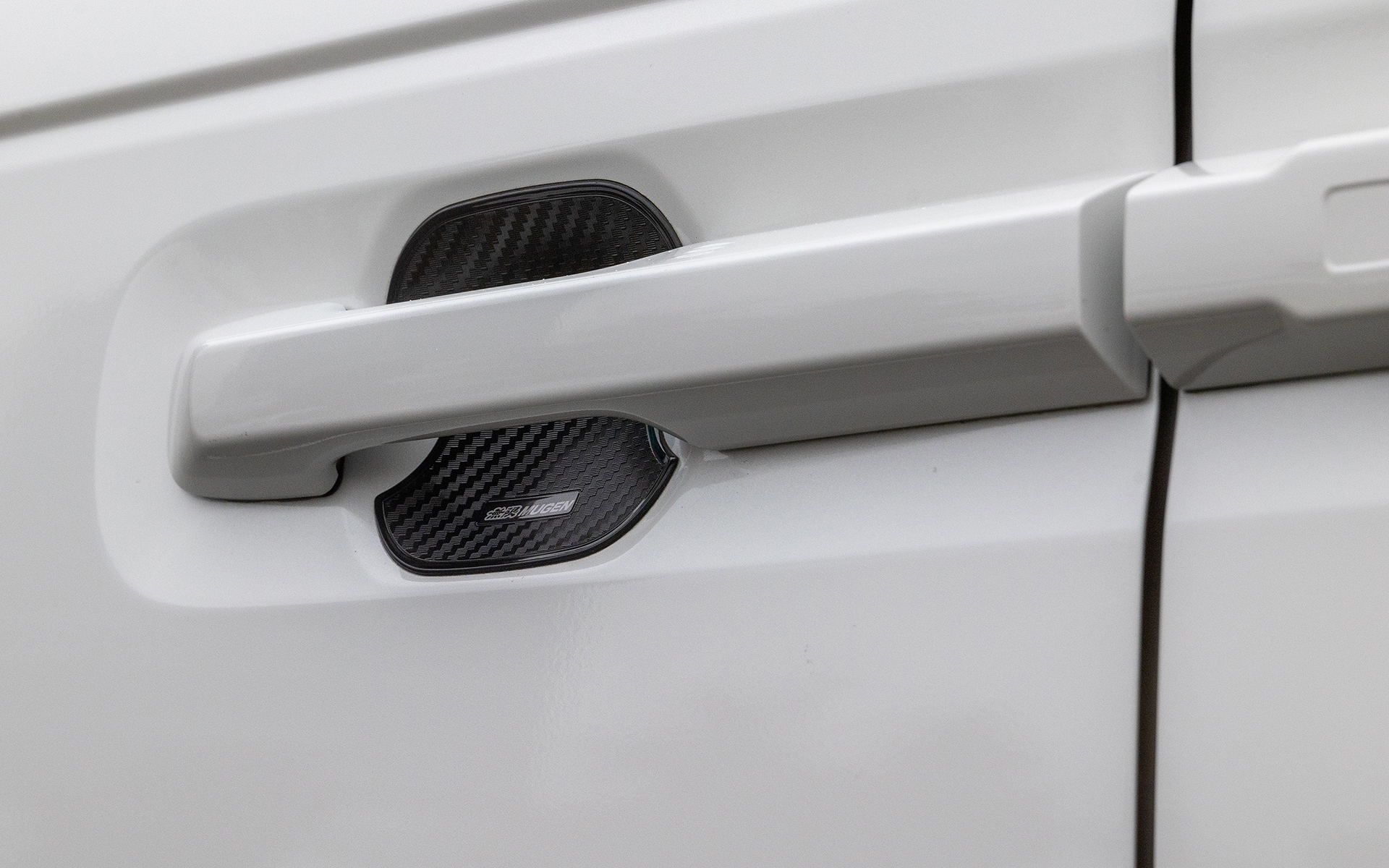 ドアハンドルプロテクター。カーボン調のシボ加工仕上げ。フロントドア用で価格は3080円