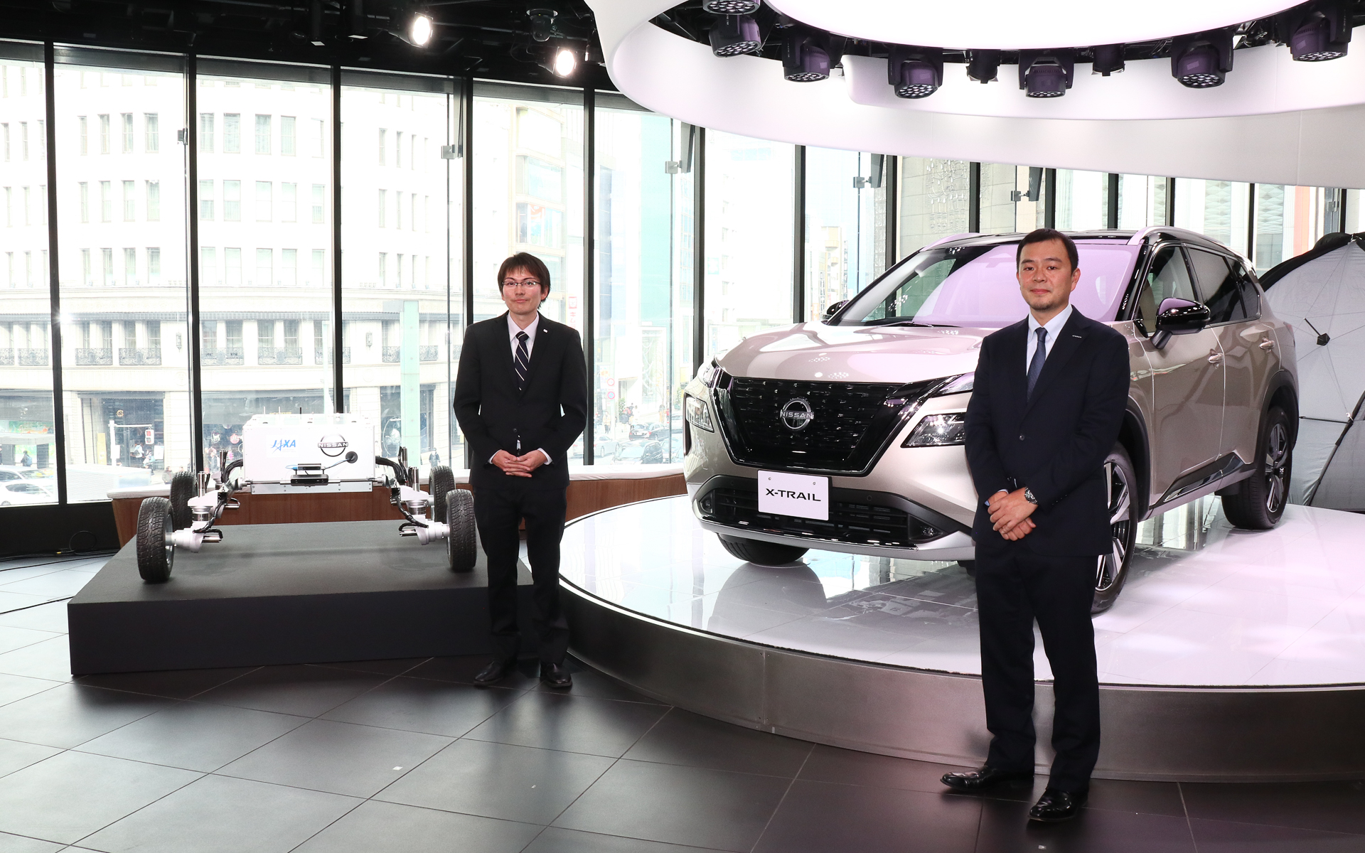 日産エクストレイルと月面ローバの前に立つJAXA 宇宙探査イノベーションハブ 須藤真琢氏（左）と日産自動車株式会社 企画・先行技術開発本部先行車両開発部 伊藤健介氏（右）