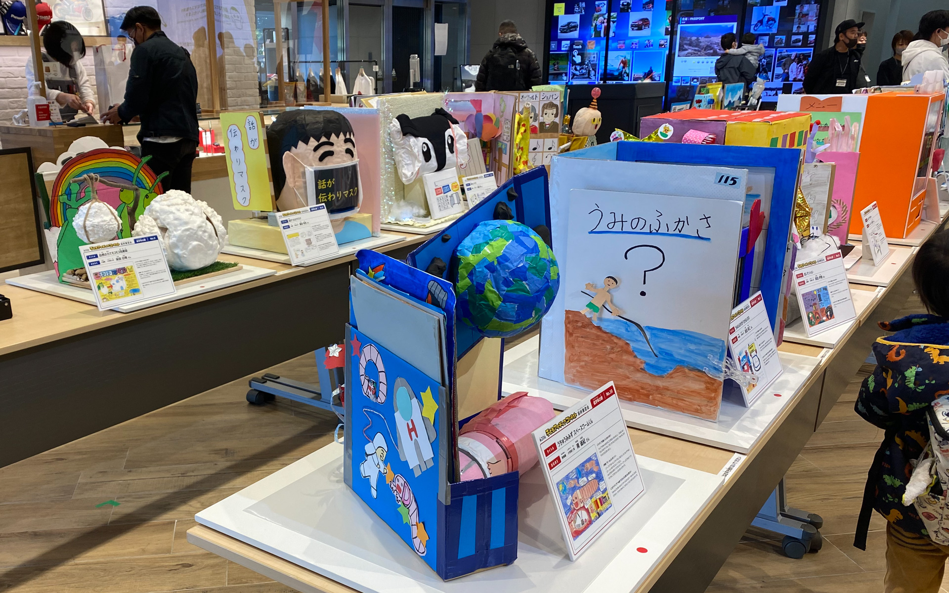 「子どもアイディアコンテスト」最終審査会の会場には、ファイナリストとなった子どもたちが苦労して完成させた、自分のアイディアを具現化した作品たちがズラリ。とても細かな造形を工夫して作っている様子は、じっくり見ていたら何時間もかかるほどです。今回は、食べられるマシュマロを使ったり、本棚に収まる何十冊にもなる本までコツコツと仕上げてあったり、感心しっぱなしでした