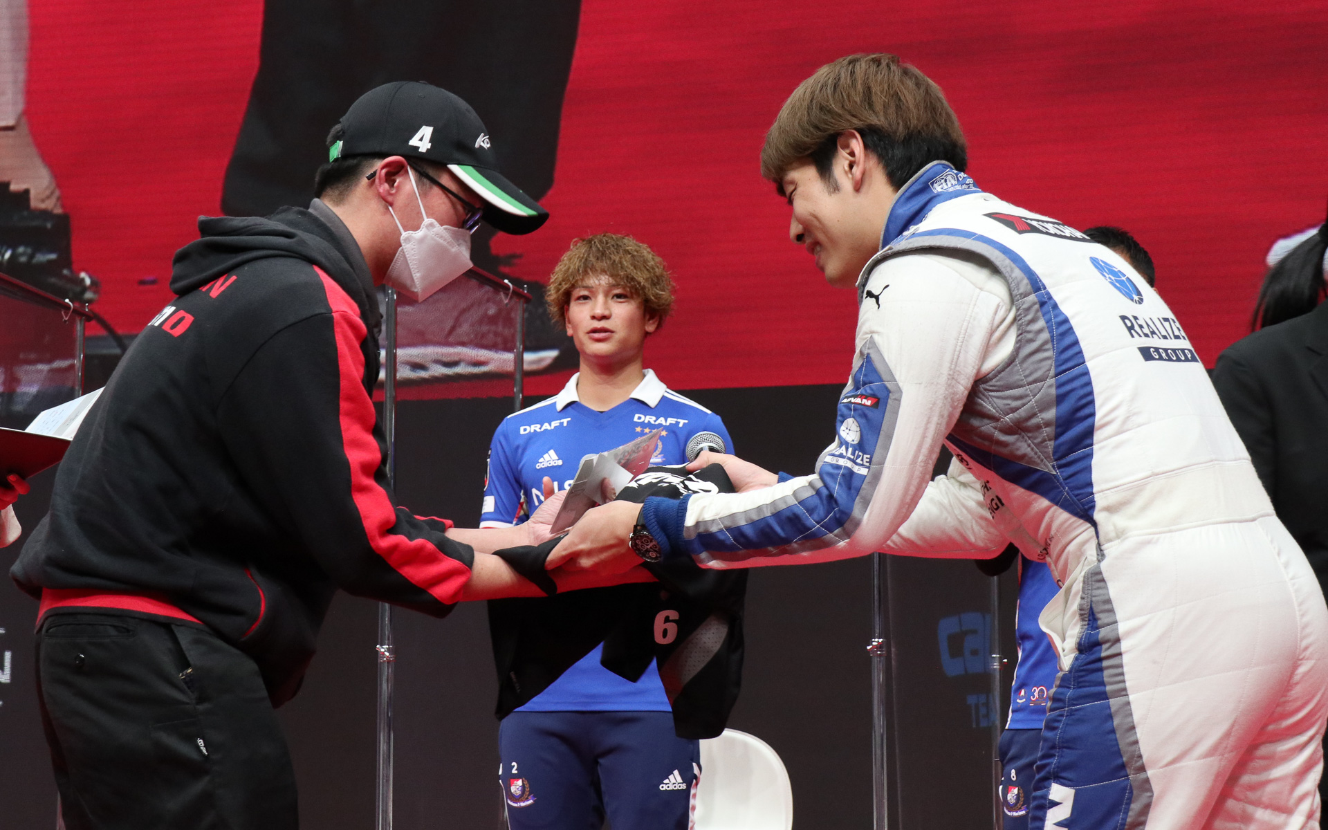 KONDO RACINGから贈られた非売品のスタッフTシャツは、藤波選手もレーシングスーツの下に着用してトークショーに臨んでいた