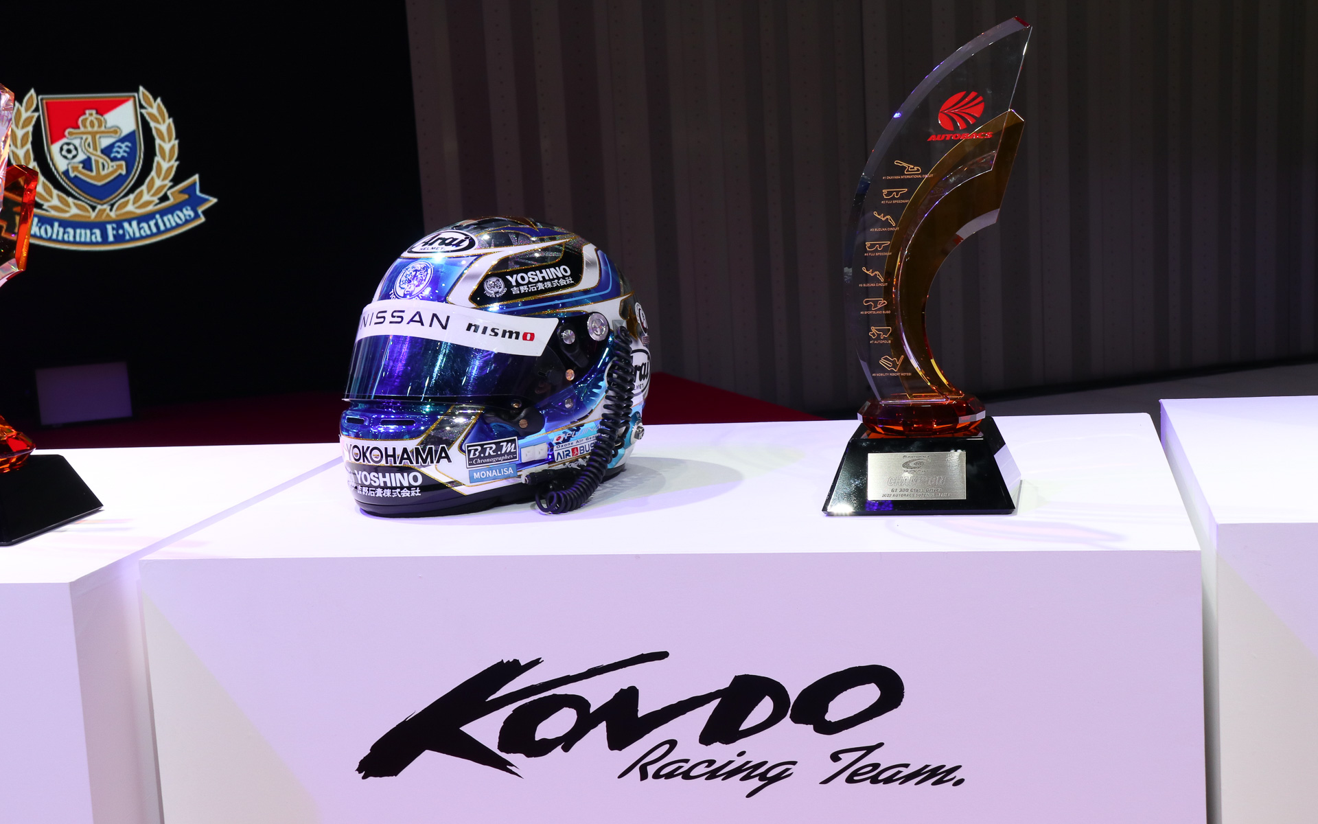 GT300クラス・ドライバーズチャンピオンのトロフィーと藤波選手着用のヘルメット