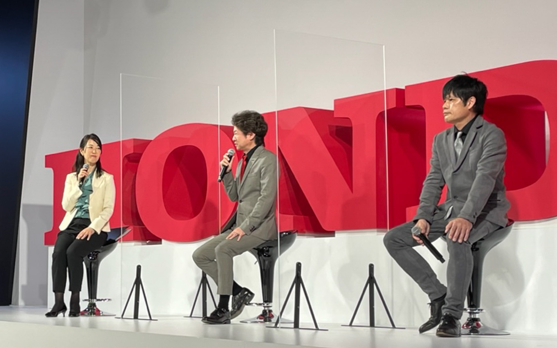 フィット開発責任者・奥山貴也さん（右）と、シビック TYPE R開発責任者・柿沼秀樹さん（中央）のトークショーは、基本的にぶっつけ本番のフリートークだったこともあって、本音のガチトークが炸裂。奥山さんが会場の皆さんへ、「ずっと立ったまま聞いて下さった皆さんのその目を、僕たち開発者は覚えています。その目に応えるために、もっともっと喜んでもらえるクルマづくりに励みますので、今後のホンダに期待してください」とメッセージを送っていて、ステージ上なのに思わずウルっときてしまいました