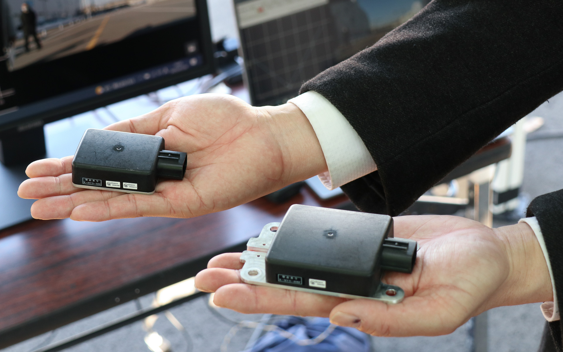 開発中のマルチファンクションミリ波レーダー。左側の小さい方が車載用（48.5×59.2×21mm［突起物を除く］）、右側はインフラ用（108.5×66×22.8mm［突起物を除く］）