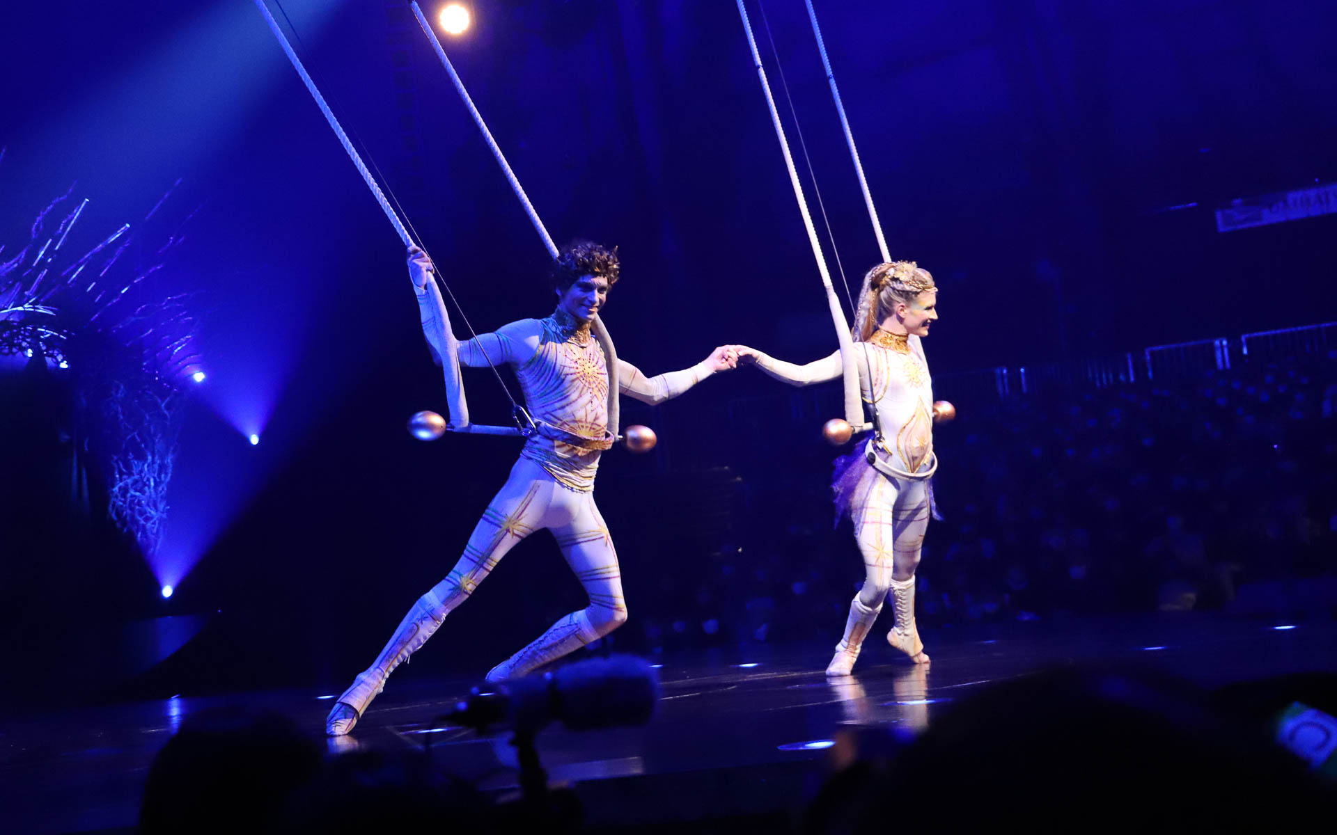 空中ブランコに乗り、息の合ったスピンや跳躍を披露するシンクロナイズド・トラピス・デュオ