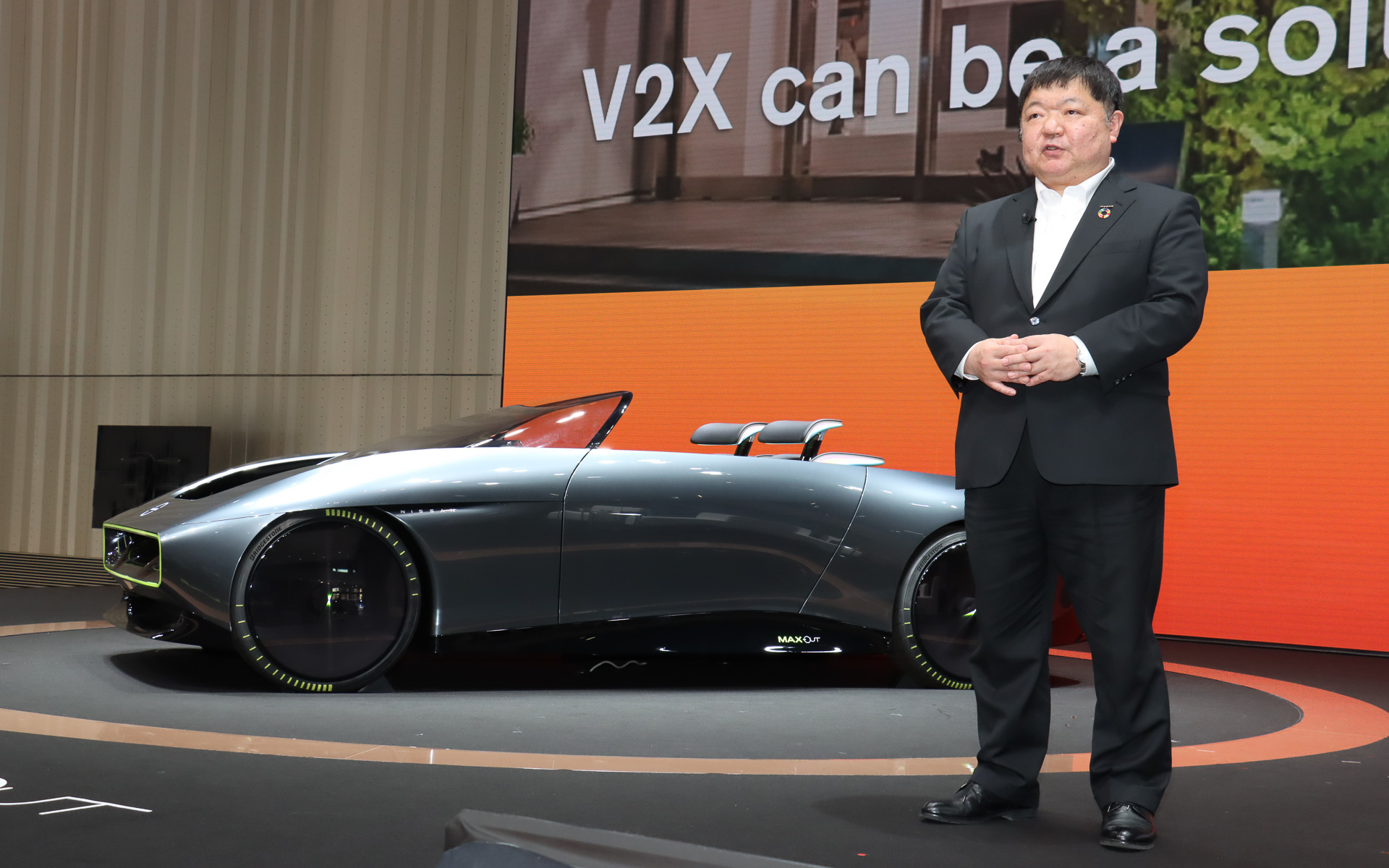 パネルディスカッション「Nissan FUTURES」で基調講演を行なう日産自動車株式会社 経営戦略本部担当 常務執行役員 真田裕氏と、2月2日に公開されたばかりのBEV（バッテリ電気自動車）コンセプトカー「Max-Out」