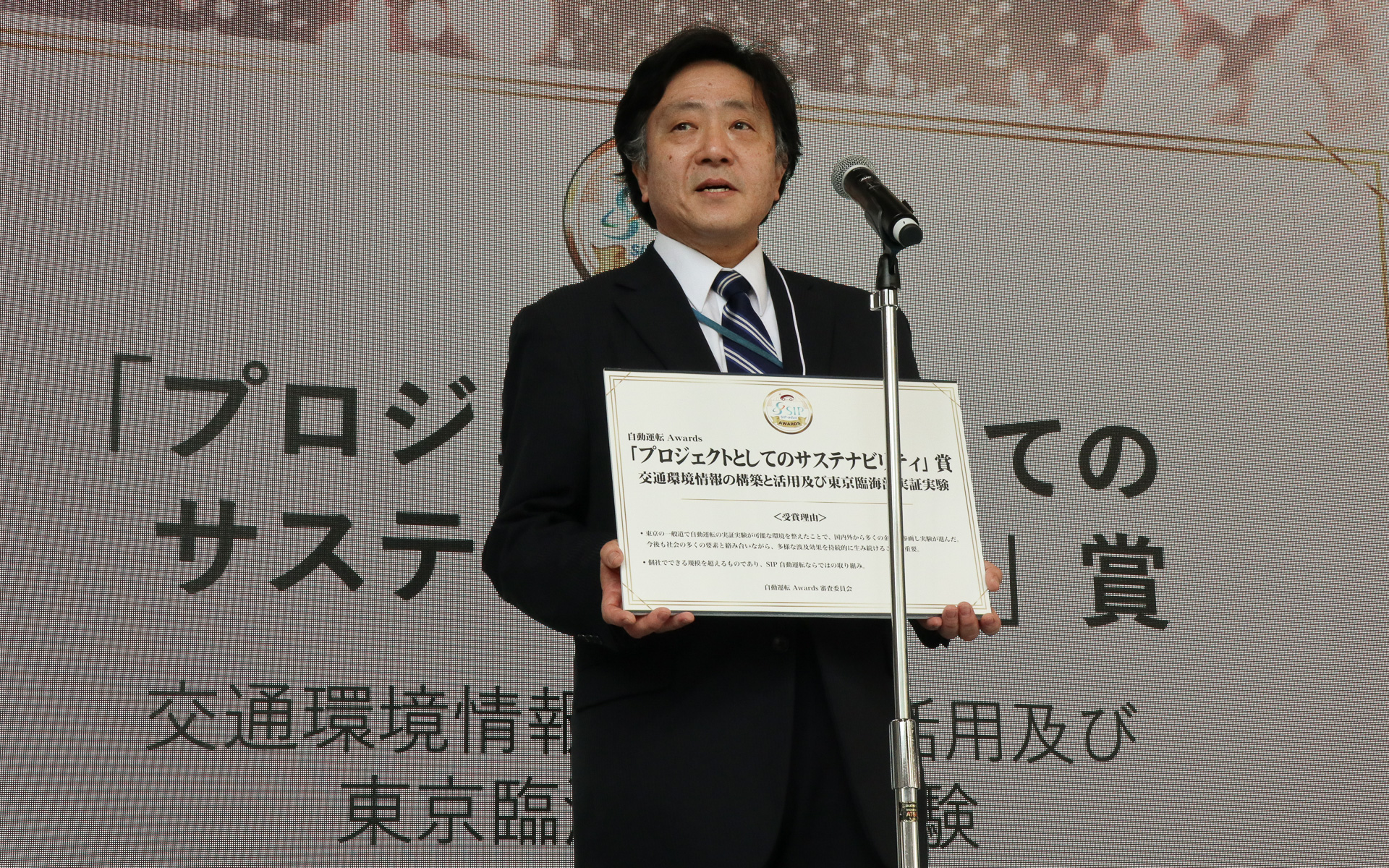 プロジェクトとしてのサステナビリティ賞「交通環境情報の構築と活用及び東京臨海部実証実験」。プロジェクトを代表して登壇した三菱電機株式会社 津田喜秋氏
