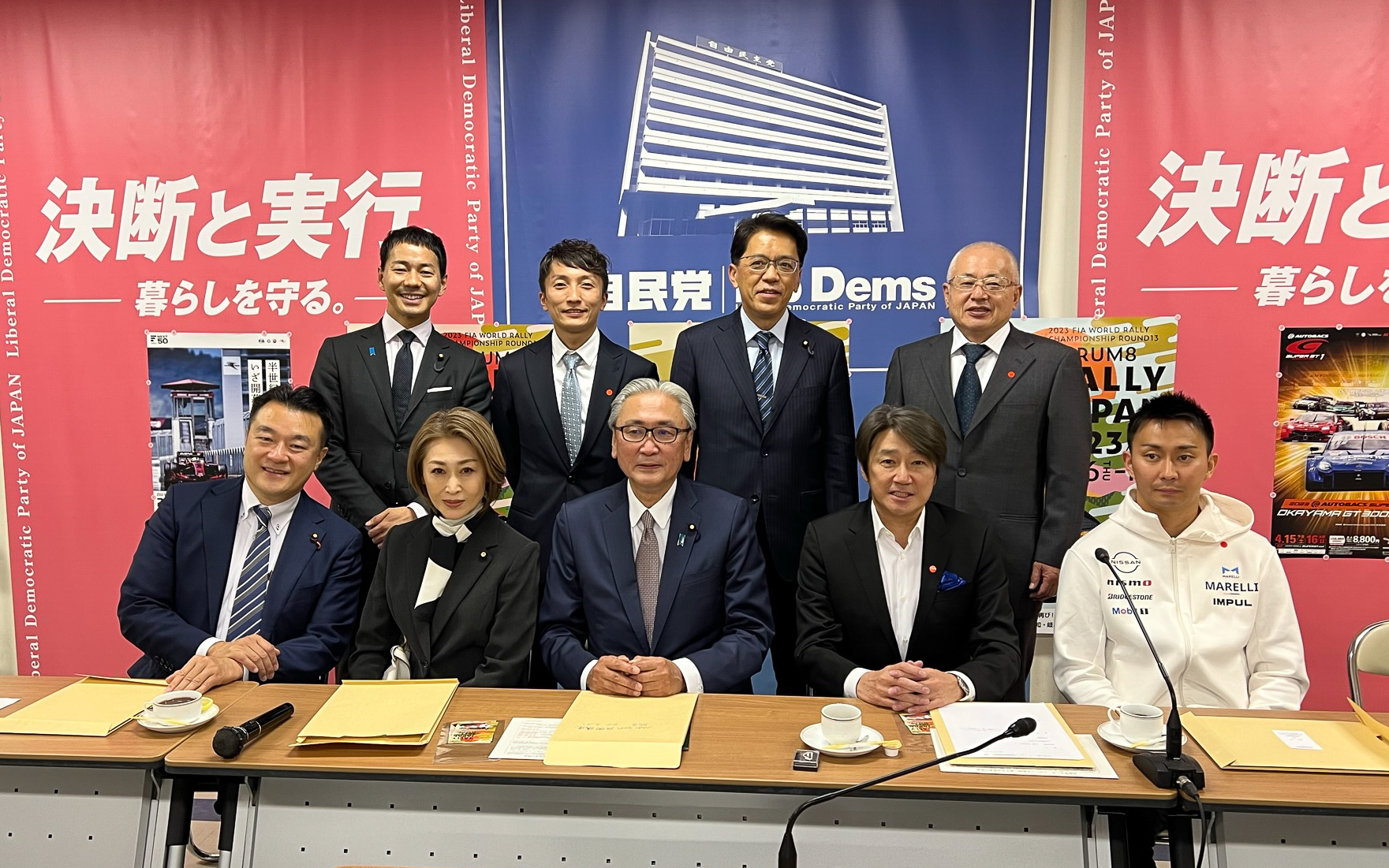 自由民主党モータースポーツ振興議員連盟総会終了後の記念写真。中央下が古屋圭司会長。その隣に三原じゅん子議員と近藤真彦JRP次期会長