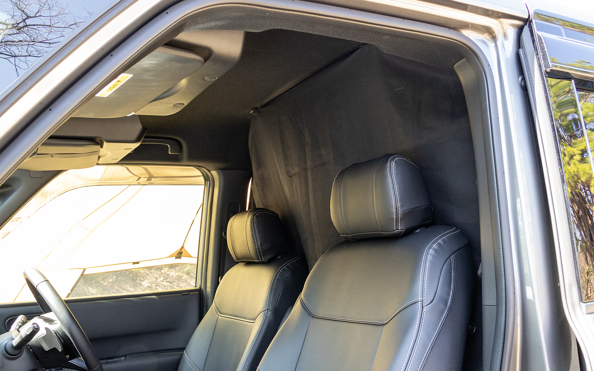 セパンレートカーテンを運転席側からみた感じ。フロントガラスに掛けるモノではないので、クルマの移動もしやすいのが特徴（カーサイドタープは吸盤取り付け）