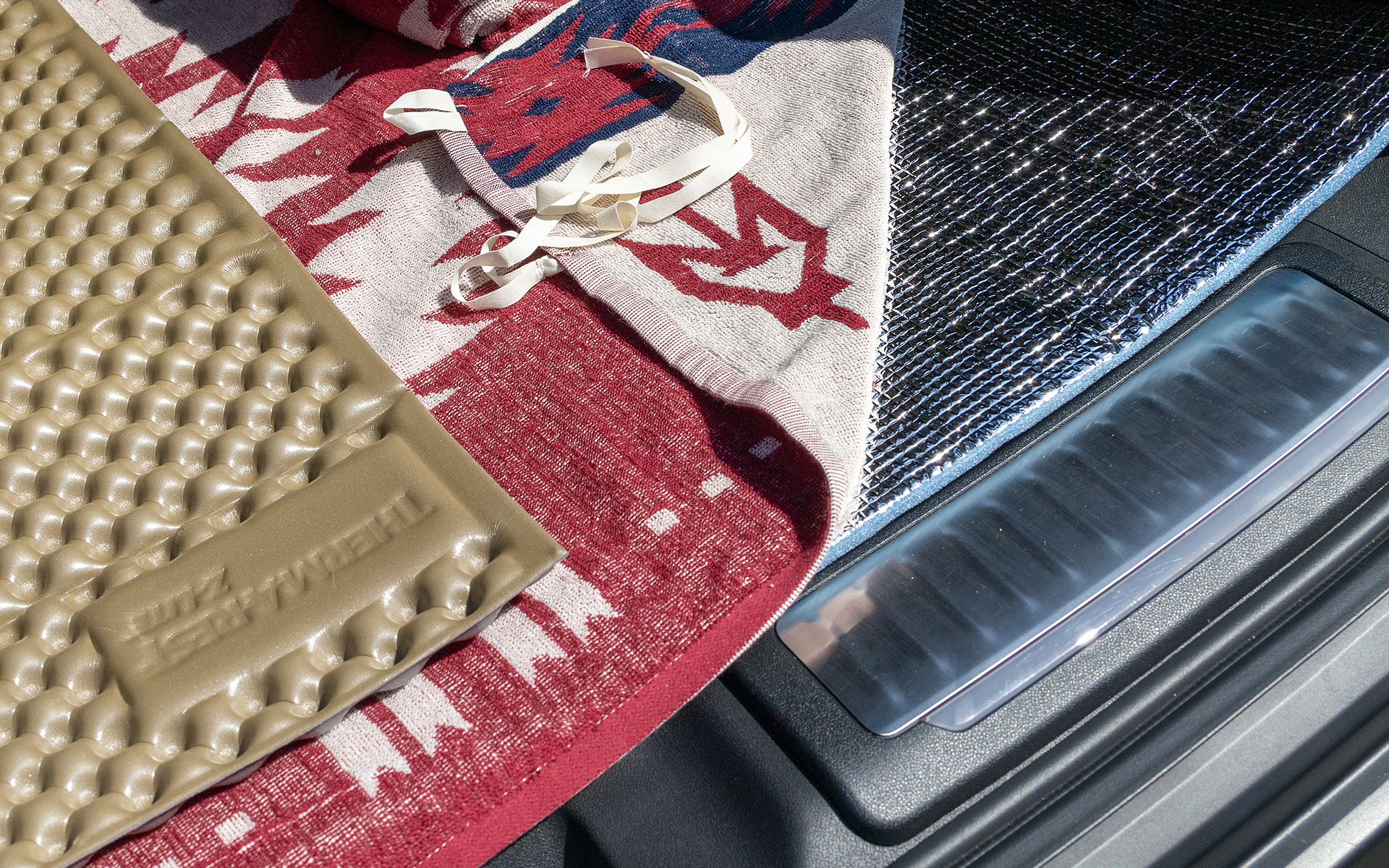 銀マットは安価で効果があるアイテム。クッション性と保温性をあげるため2枚敷いている。ただそのままでは味気ないのでラグを上に敷いている