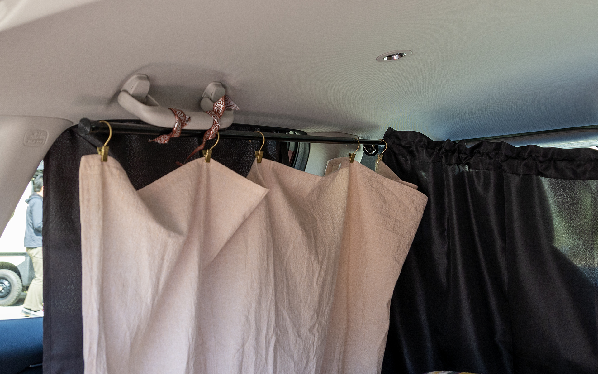 汎用カーテンだけでは雰囲気が出ないので、自分が気に入ったカーテンを追加。カーテンレールは100円均一で買える突っ張り棒を使用。ひもなどを使って簡易的に固定。ひもも自分の好みの柄を選択して楽しむ