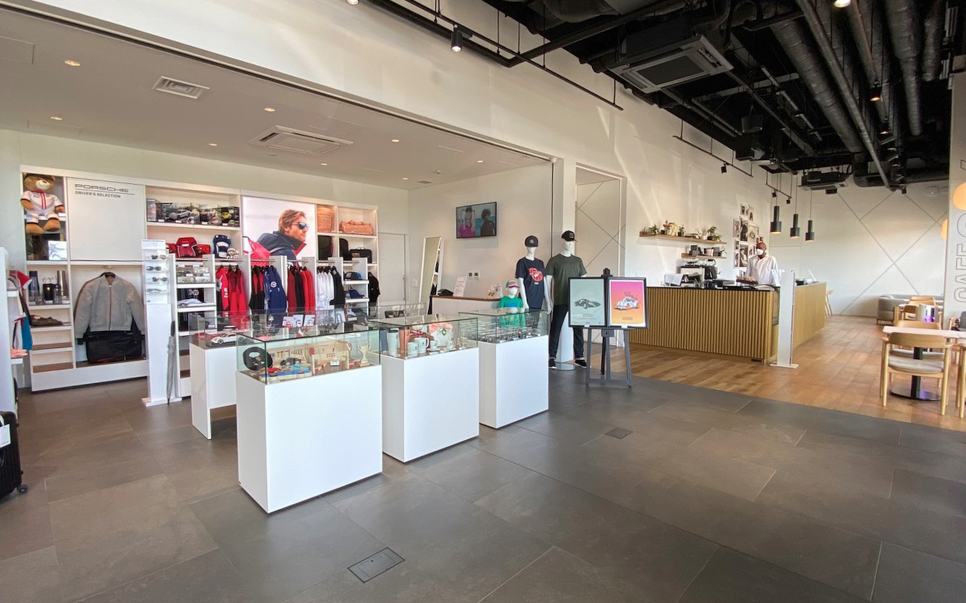 これからちょくちょく木更津方面でロケの帰りに立ち寄ってしまいそうな、カフェ956（右手）。ハンドリングコースへ出ていくポルシェが間近で見られて、緑あふれる景色が気持ちのいい空間です。お隣りのショップにはキッズ向けのアパレルやマグカップなどの小物もたくさんあって、ついついお財布を握りしめてしまいました