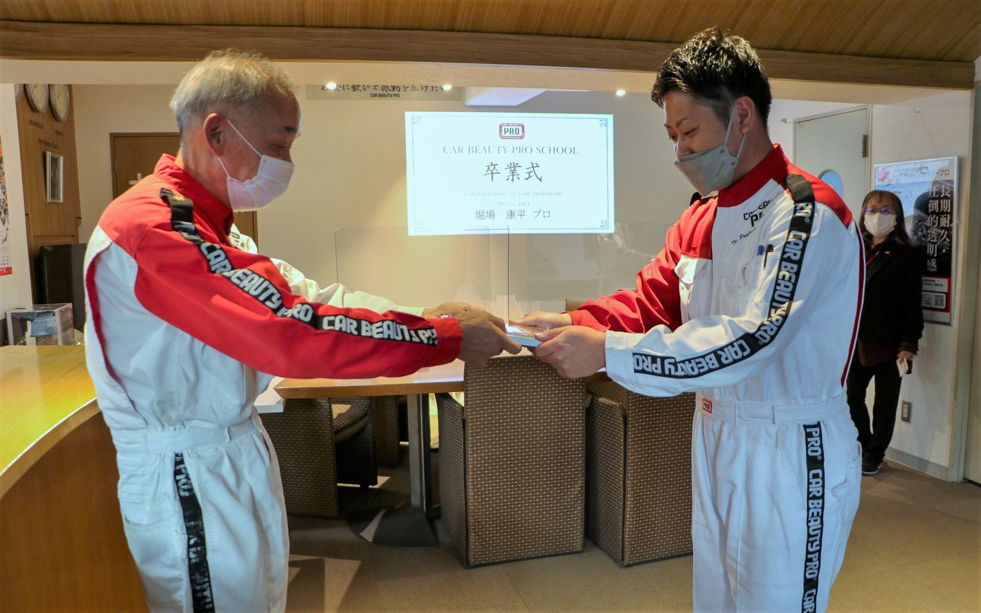 技術を習得し、卒業の証であるカービューティープロの認定盾を授与された堀場氏