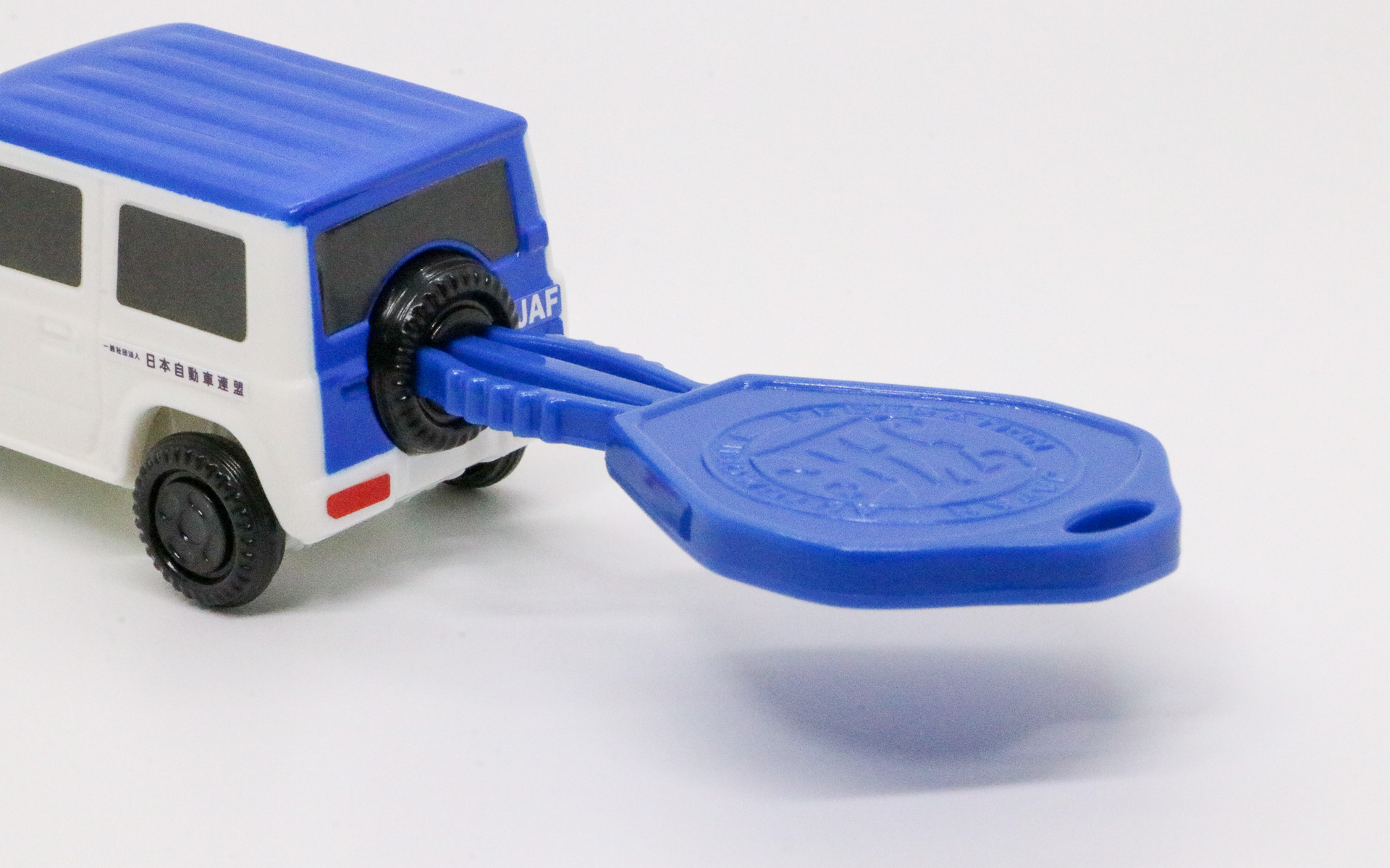 背面の穴に付属のキー差し込み、キーの中央部をつまむとクルマが走るギミックを搭載している