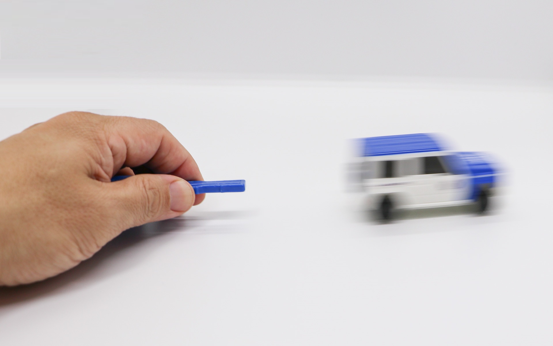 背面の穴に付属のキー差し込み、キーの中央部をつまむとクルマが走るギミックを搭載している