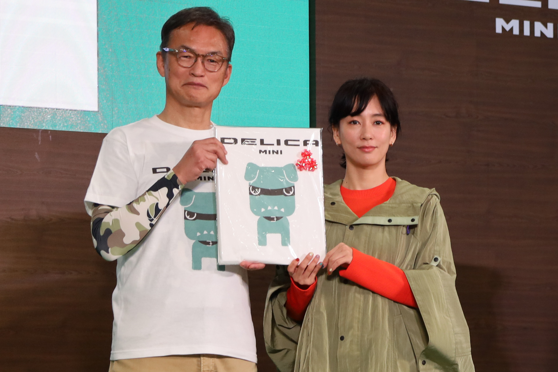 三菱自動車工業株式会社 代表執行役副社長（営業担当）の中村達夫氏が登場、デリカミニの化身がプリントされたTシャツがプレゼントされた