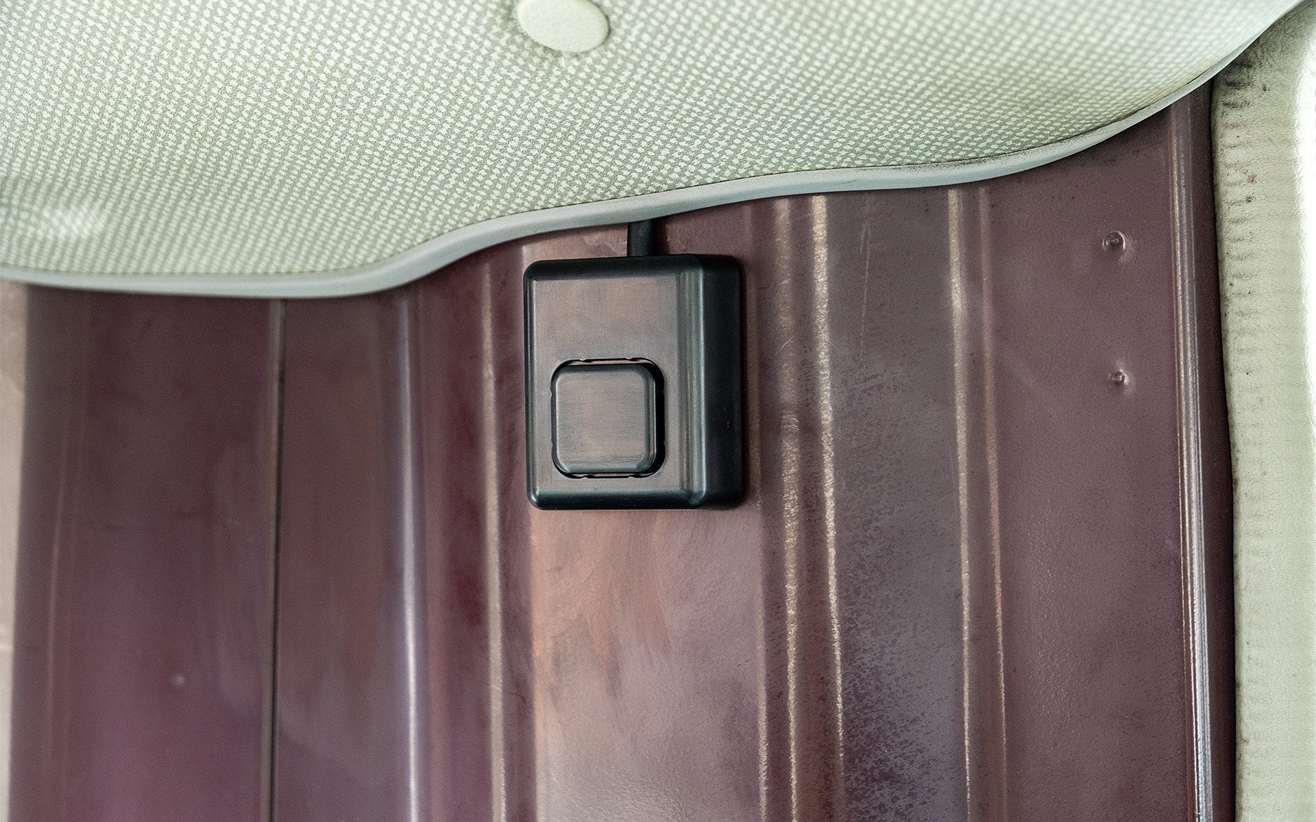 車内の最後部に取り付けられた安全確認ボタン。NP1特別仕様モデルは送迎バスのエンジン停止後に乗務員が安全確認ボタンを押すまでブザーや音声で乗務員に警告する。安全確認ボタンは室内の高い位置に付けることで、置き去りにされた子どもが誤って操作できないようにしている