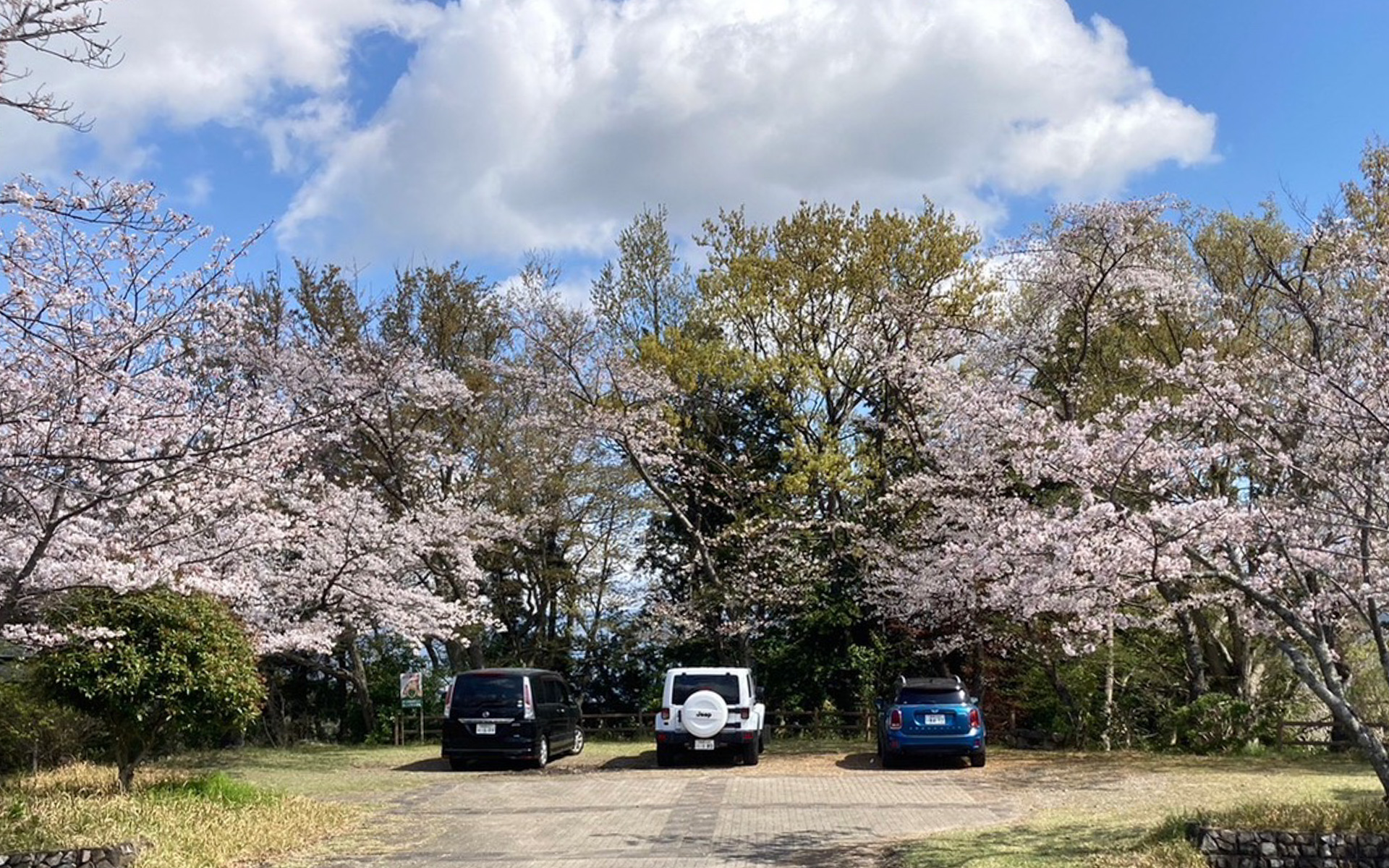 かなりの急勾配で、クネクネとした山道をのぼっていくと到着するのが、この源氏山の山頂広場。一部区間はすれ違い困難な感じなので注意が必要ですが、わりと広めの駐車場がありました。眺望もよく、ここからさらに徒歩で行ける展望広場もあります。ハイキングを楽しんでいるご夫婦にも出会いました