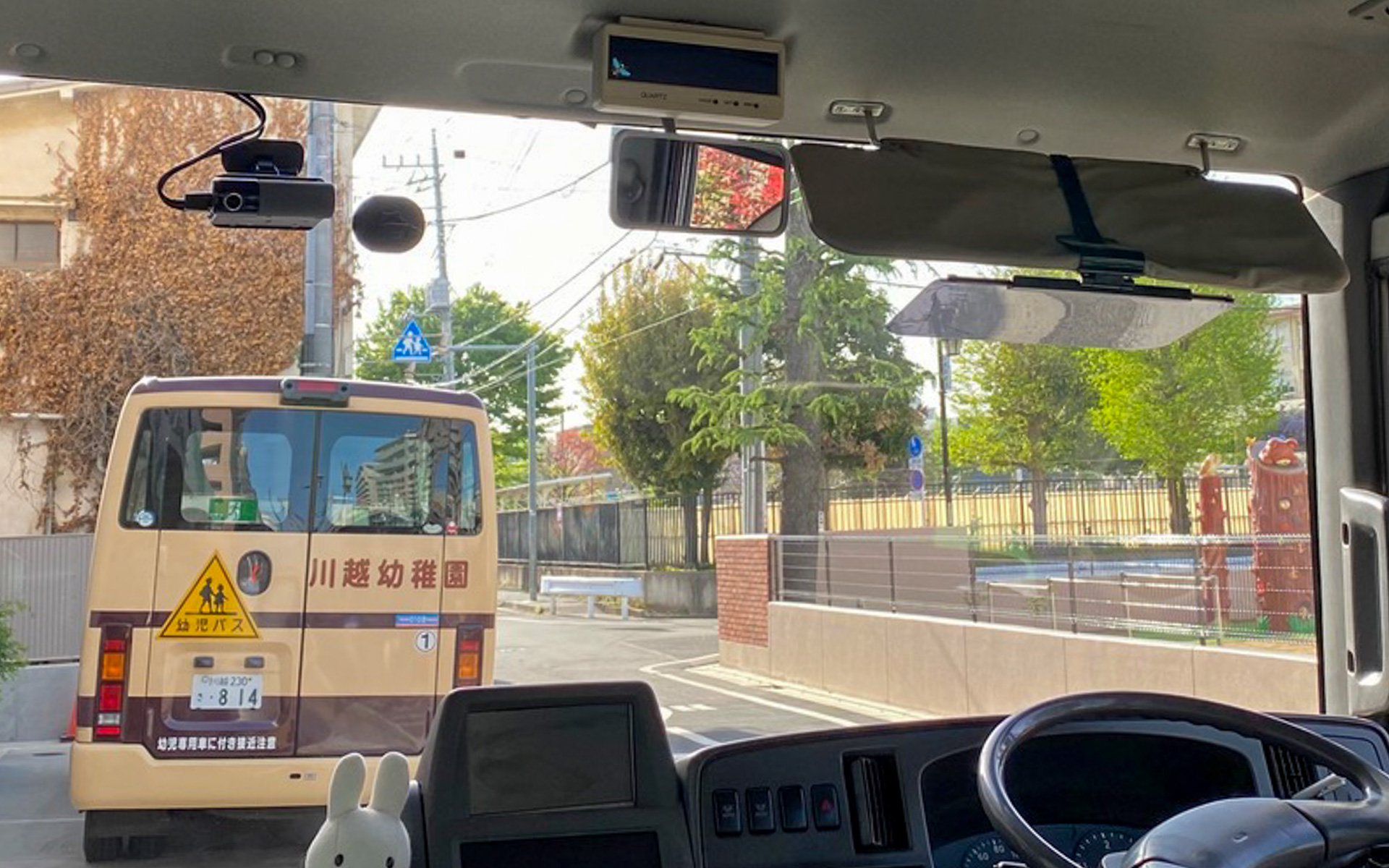 大きなフロントガラスの左上に設置されているのが、国土交通省が定めたガイドラインに従い、車内置き去り防止機能に特化しているNP1の特別仕様です。商品構成はNP1特別仕様　本体、バッテリーケーブル　ハブシステム、車外警報用ホーン12V用24V用、確認装置（スイッチ）、専用アプリ、書類一式、取付用品となっていて、価格は12万9800円。通信＋サービス利用料1年分が含まれています。一部車種を除き、本体＋取付費用は、補助金上限額でおさまるとのこと