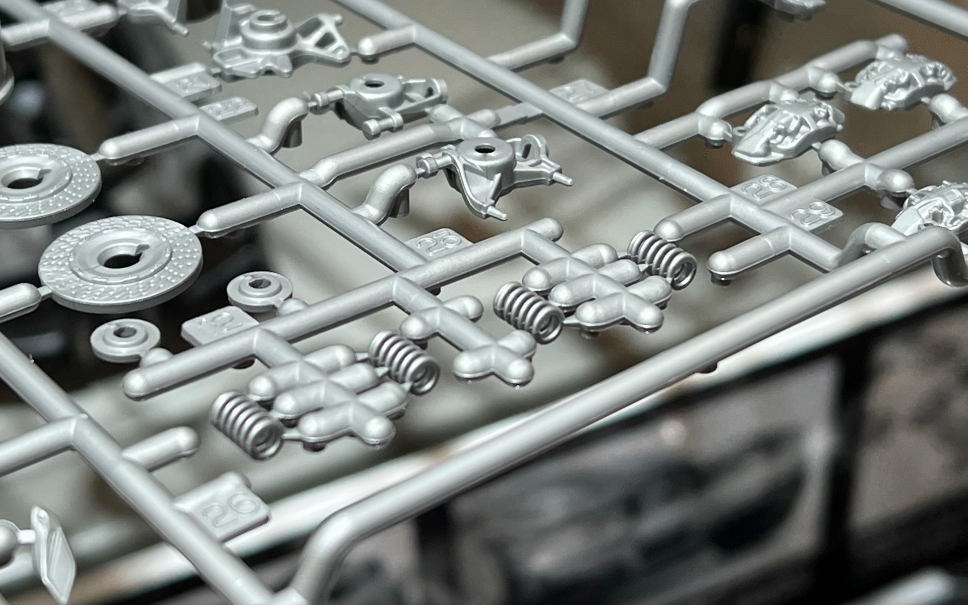 成形部品。手前のランナーが盛り上がっているのはスライド金型の逃げ。コイルのまわりに使われていない湯口があるのは試行錯誤の痕跡