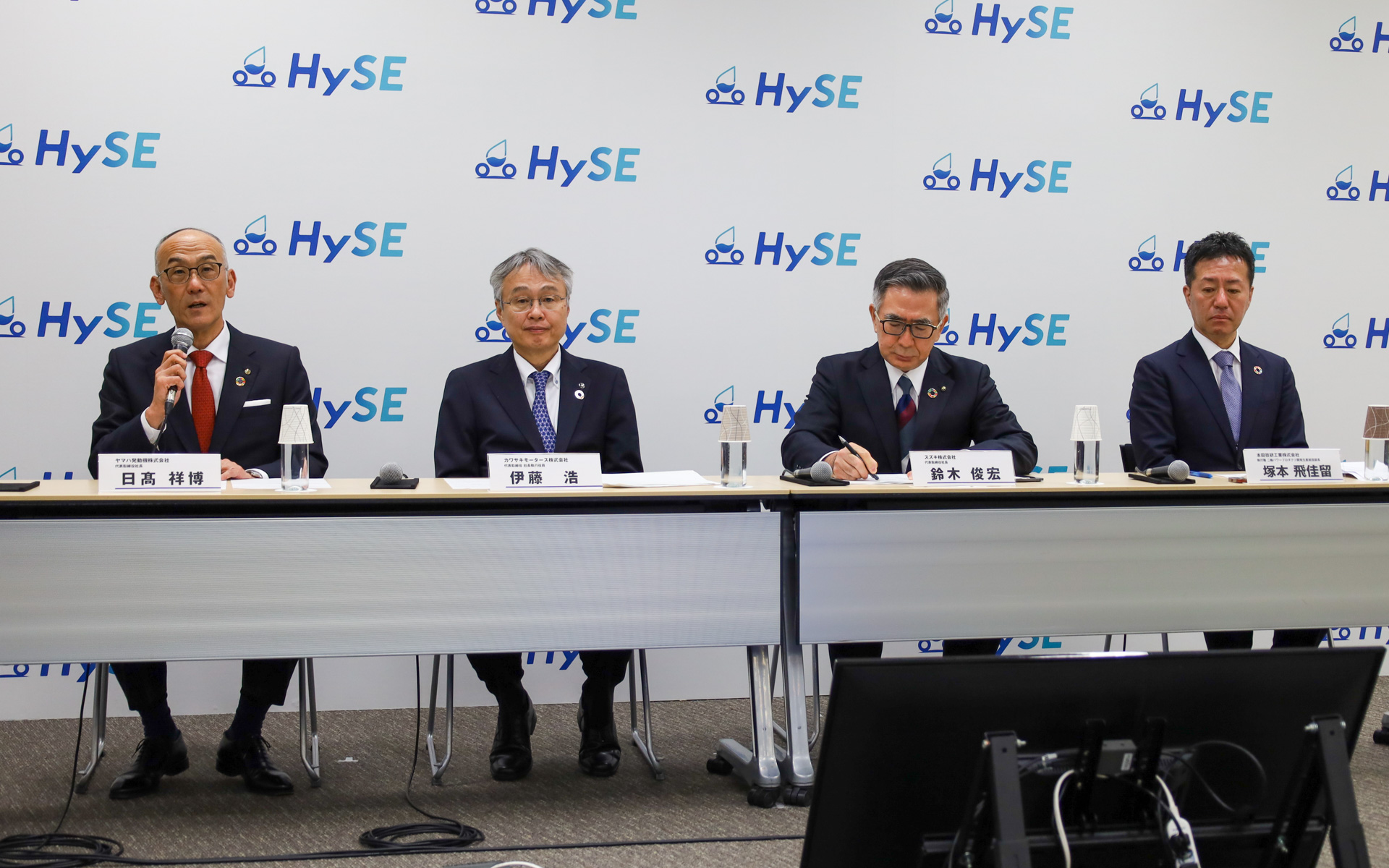 説明会では、ヤマハ発動機 代表取締役社長 日髙祥博氏、カワサキモータース 代表取締役 社長執行役員 伊藤浩氏、スズキ 社長 鈴木俊宏氏、本田技研工業 執行職 二輪パワープロダクツ開発生産統括部長 塚本飛佳留氏、各社代表者が登壇して、意気込みを述べた。