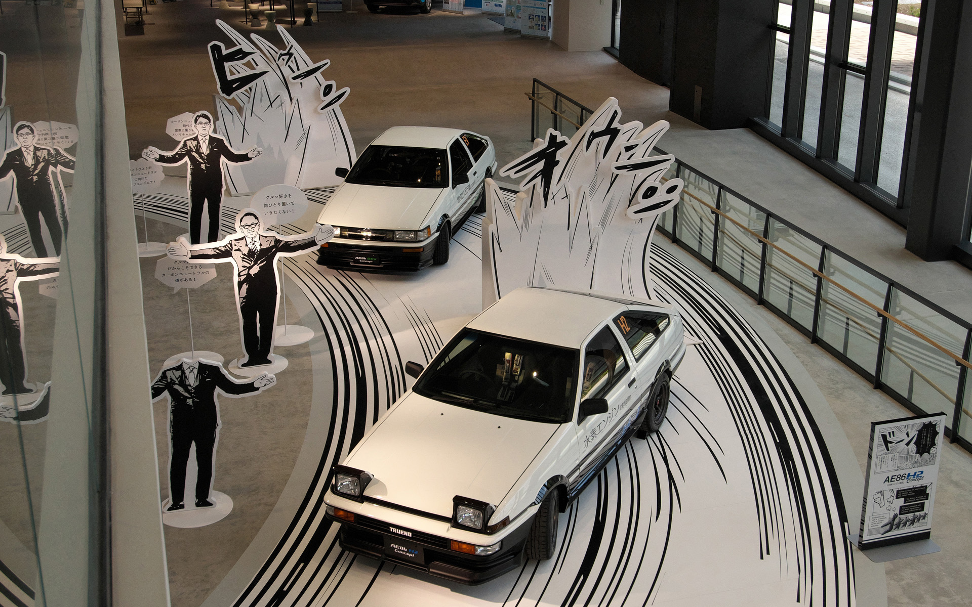 コミックのように展示された水素のトレノとバッテリEVのレビン。豊田章男会長の顔ハメパネルも飾られていた