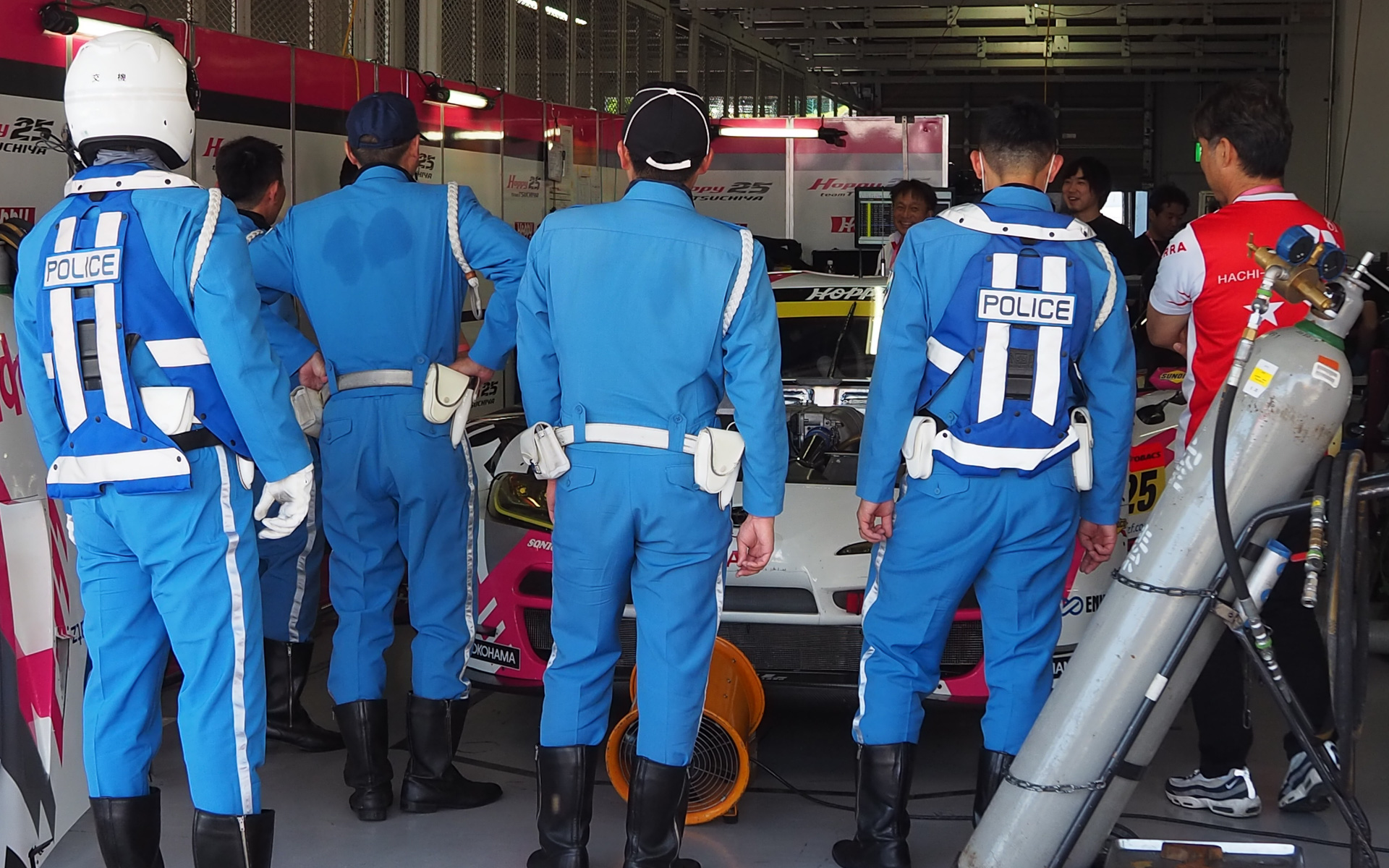 決勝レース前にフォーメーション走行を披露した三重県警の警察官もGTマシンに興味津々