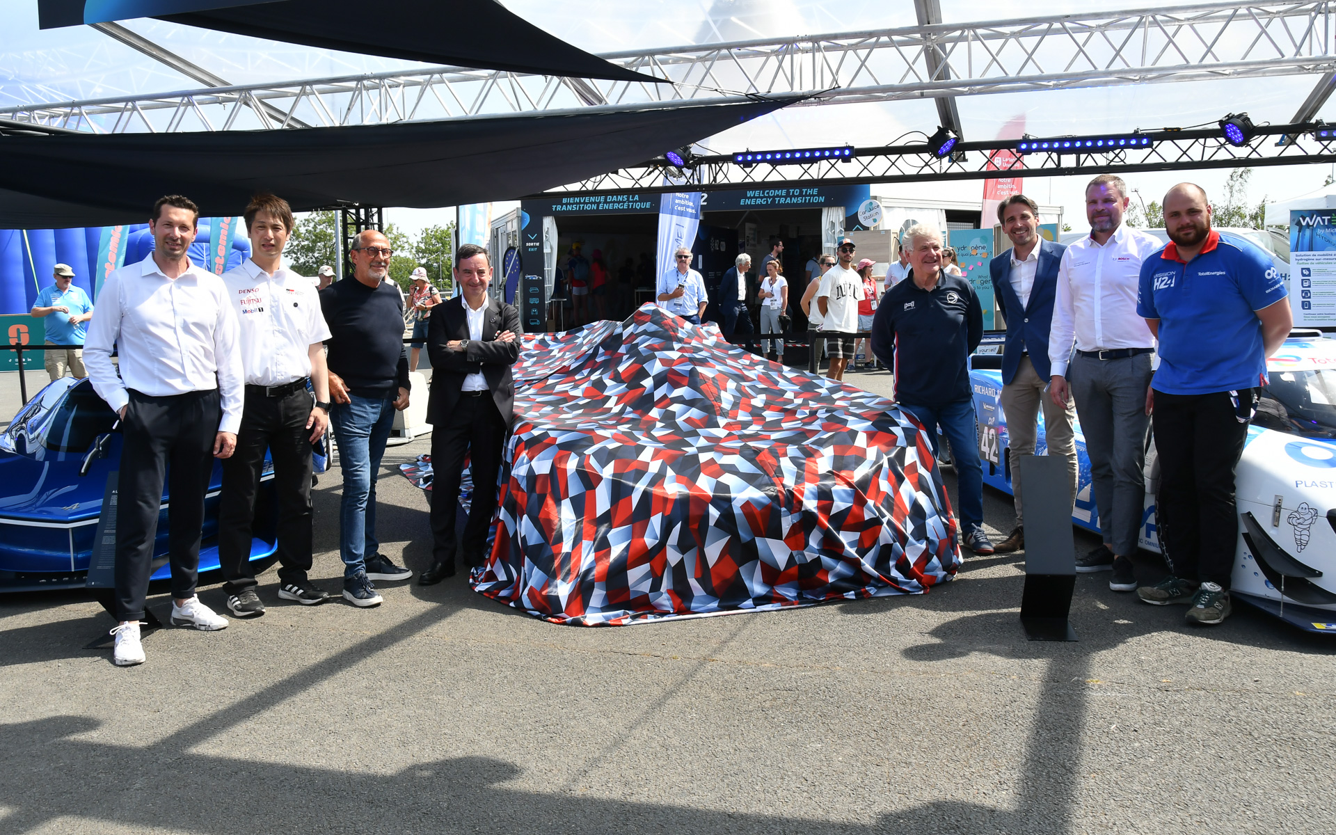 トヨタのミステリーカーの前で記念写真。ACO会見後の9日にアンベールされる予定