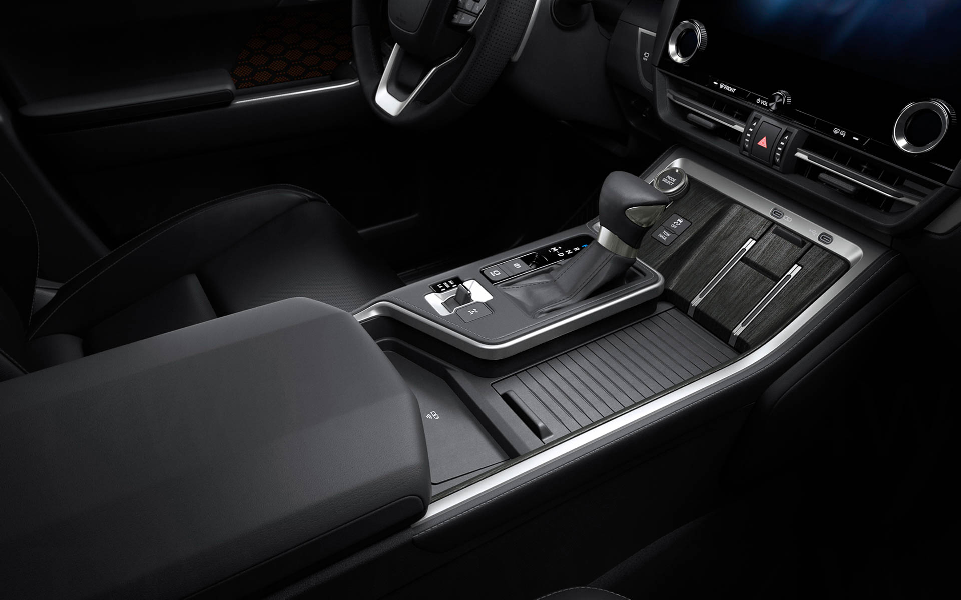 オフロード走行時の操作性を考慮し、ドライバー側に走行系や駆動系スイッチを機能別に配置。カップホルダーにはスライドリッドを採用し、閉じるとスマートフォンなどのデジタルデバイスを置くスペースとなる