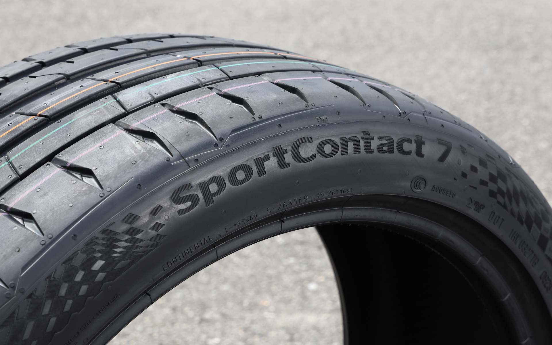 コーナリング時にもっとも大きな力を伝達するアウターショルダーの接地面積を最大限に確保。アウターショルダー部のグループ内に設置された「インナーロック・エレメント」によりトレッドパターンの変形を抑制する。タイヤのサイド部にチェッカーフラッグの模様を施してスポーティさを強調した