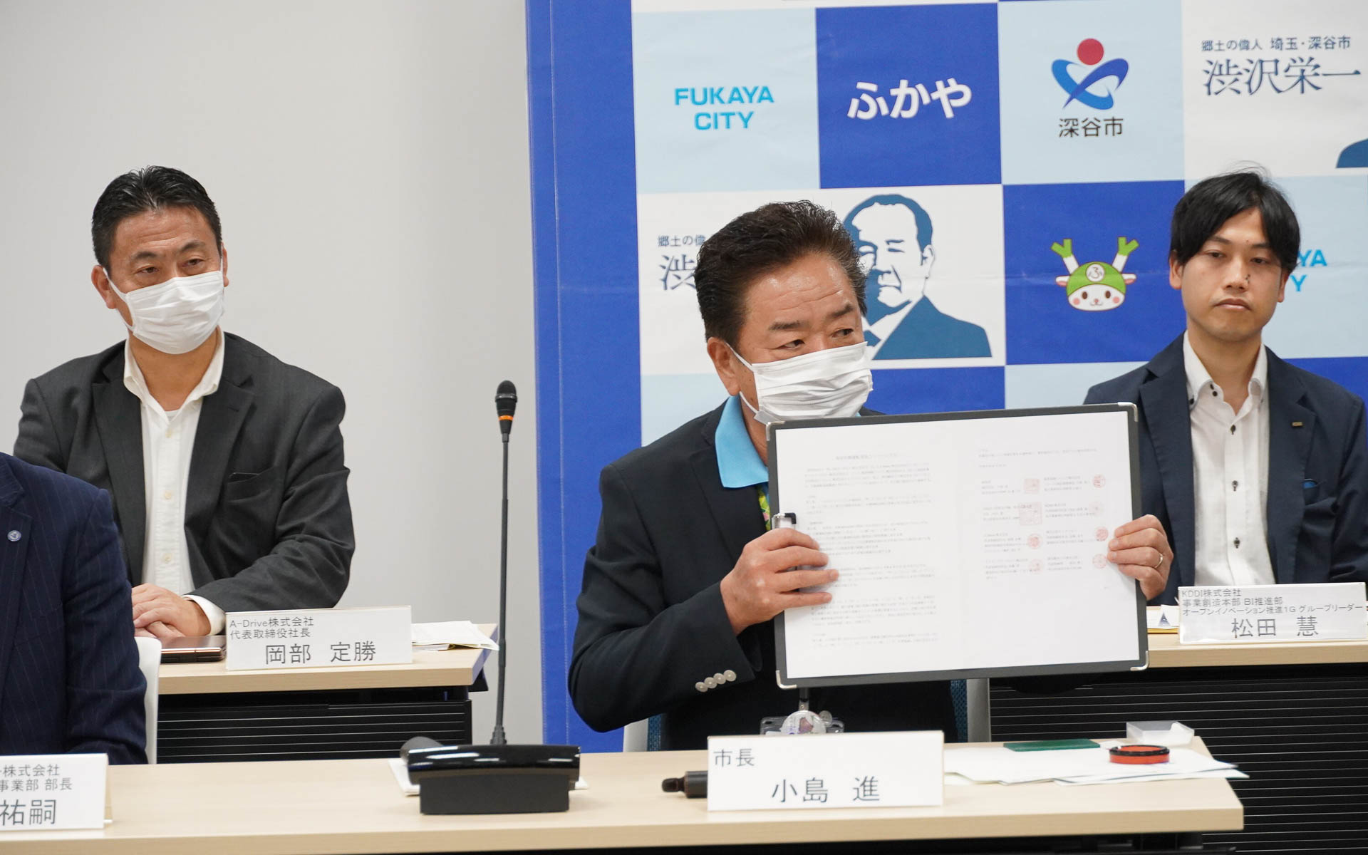 協定締結書を手に持つ深谷市の小島進市長
