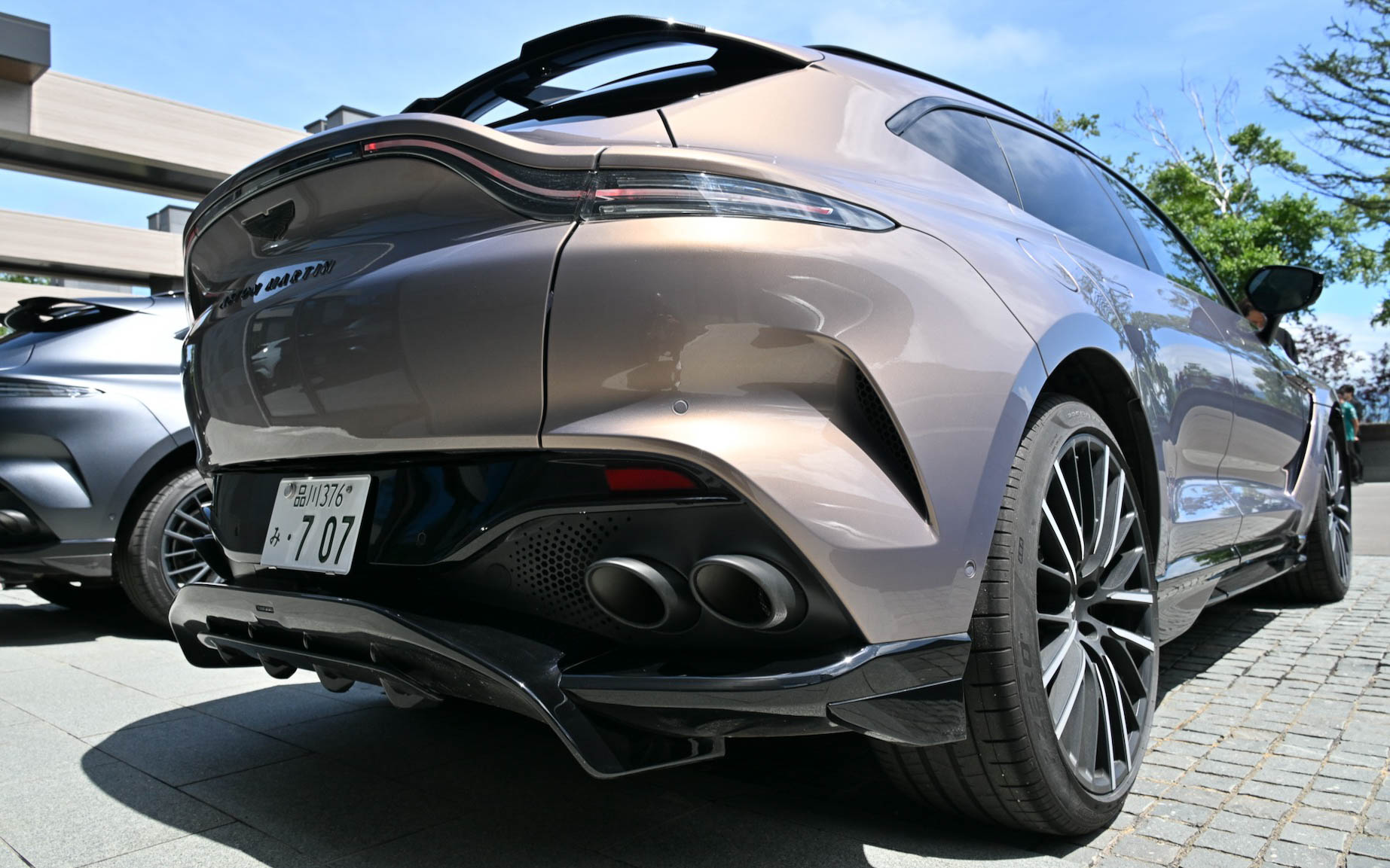 ボディサイズは5039×1998×1680mm(全長×全幅×全高)、ホイールベースは3060mmで、乾燥重量は2245kg。23インチのホイール内に収められるブレーキはフロント420×40mmディスク、リア390×32mmディスクを採用。ブレーキディスクはカーボンセラミック製のベンチレーテッド&溝付き2ピース、セミフローティング構造で、キャリパーはフロントがアルミニウム製フロント6ピストン・モノブロックキャリパー、リアがアルミニウム&鋳鉄製スライディング・シングルピストンキャリパー、一体型パークブレーキとなる。フロントとリアにはクローム加工の真鍮とエナメル製の手仕上げのアストンマーティン・バッヂを装着