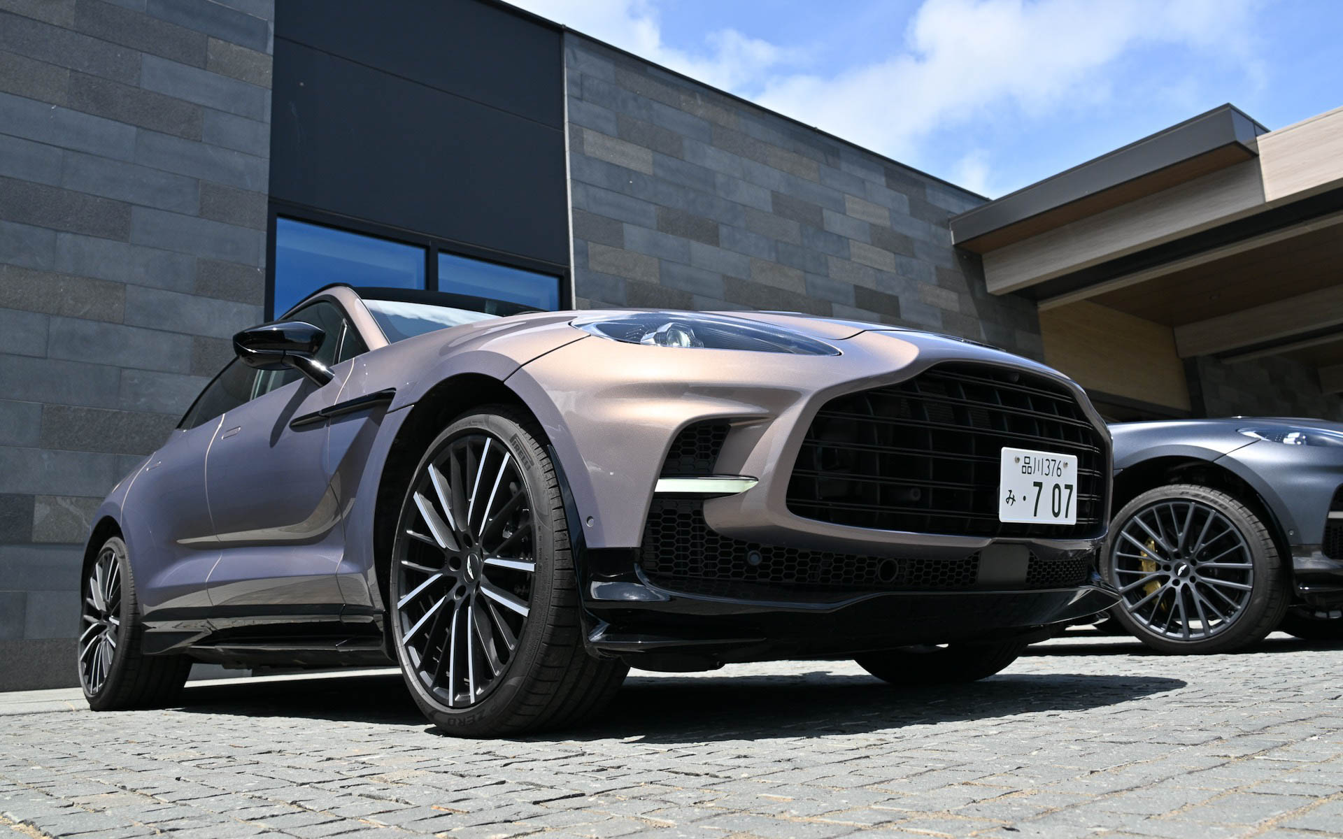 ボディサイズは5039×1998×1680mm(全長×全幅×全高)、ホイールベースは3060mmで、乾燥重量は2245kg。23インチのホイール内に収められるブレーキはフロント420×40mmディスク、リア390×32mmディスクを採用。ブレーキディスクはカーボンセラミック製のベンチレーテッド&溝付き2ピース、セミフローティング構造で、キャリパーはフロントがアルミニウム製フロント6ピストン・モノブロックキャリパー、リアがアルミニウム&鋳鉄製スライディング・シングルピストンキャリパー、一体型パークブレーキとなる。フロントとリアにはクローム加工の真鍮とエナメル製の手仕上げのアストンマーティン・バッヂを装着