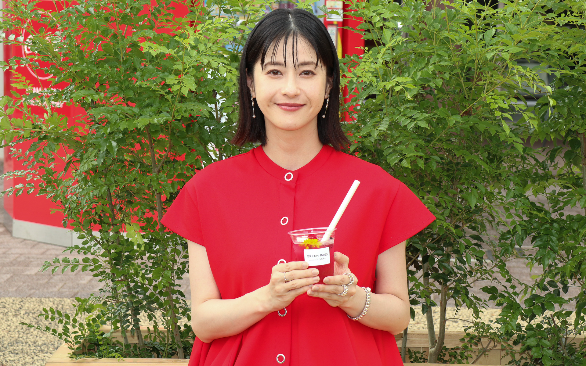 レストスペースのベンチに座ってスペシャルチャージドリンクをアピールする松本さん