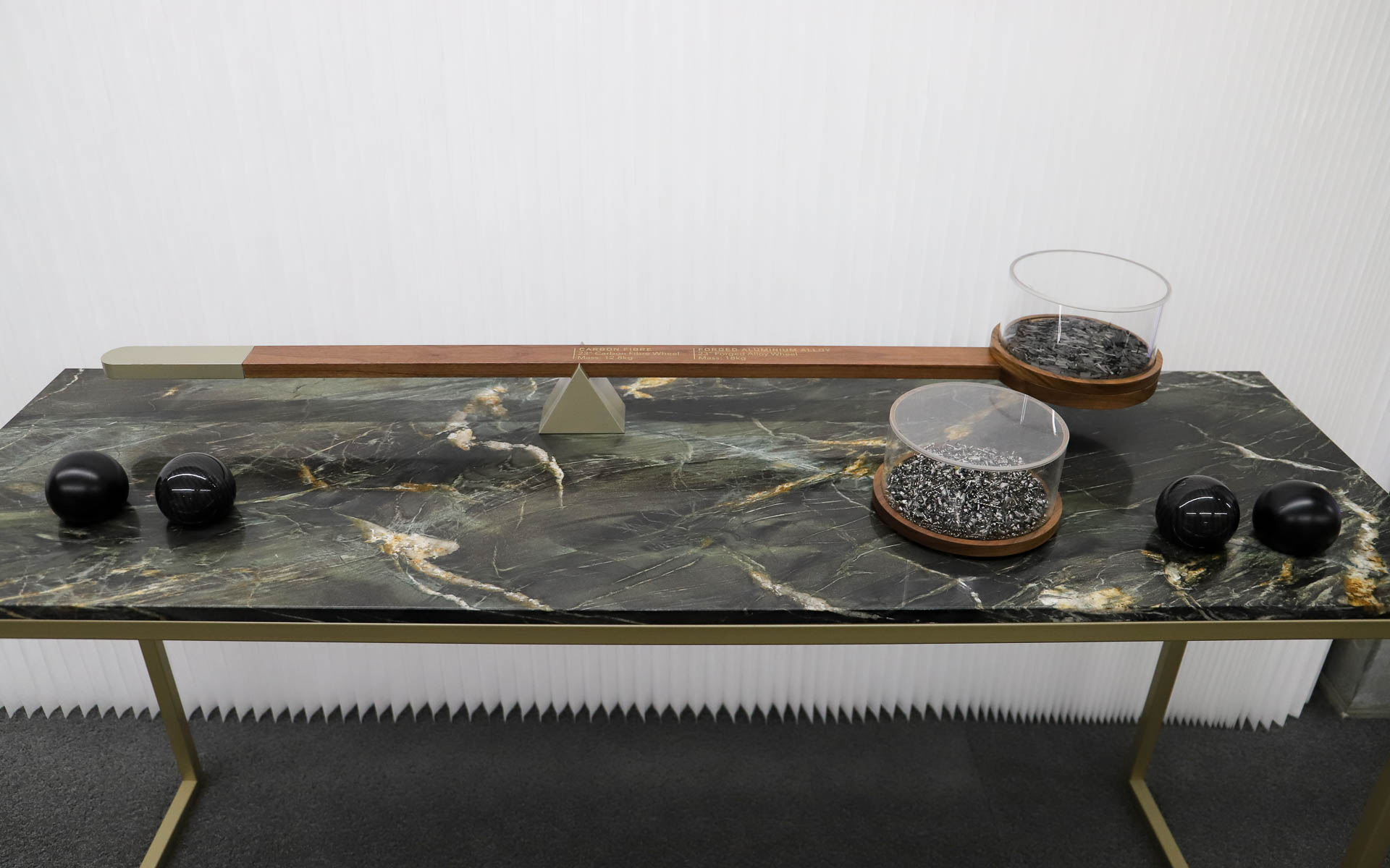 カーボンとアルミの重さの違いを体感できるパート。カーボンを乗せると天秤は釣り合うが、アルミを乗せると傾いてしまう