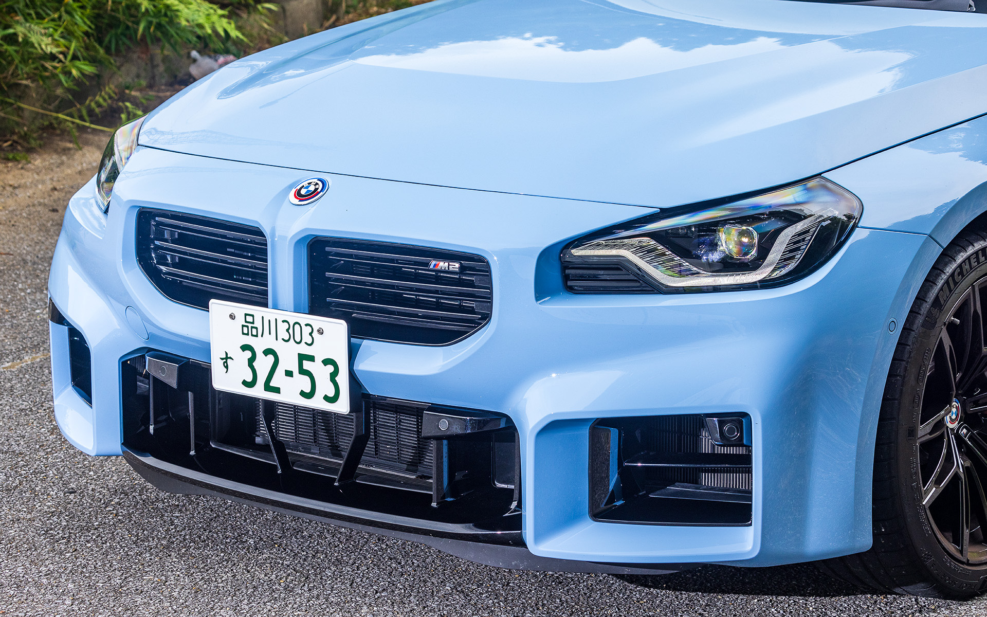 新型M2は2シリーズ クーペをベースとしながら大きく左右に張り出した四角型基調のエアインテーク、ヘッドライトまわりのデザイン、横バーを採用した直線的なデザインのフレームレスのキドニーグリル、横方向にワイドにしたフロントホイールハウスなどにより存在感を強調した