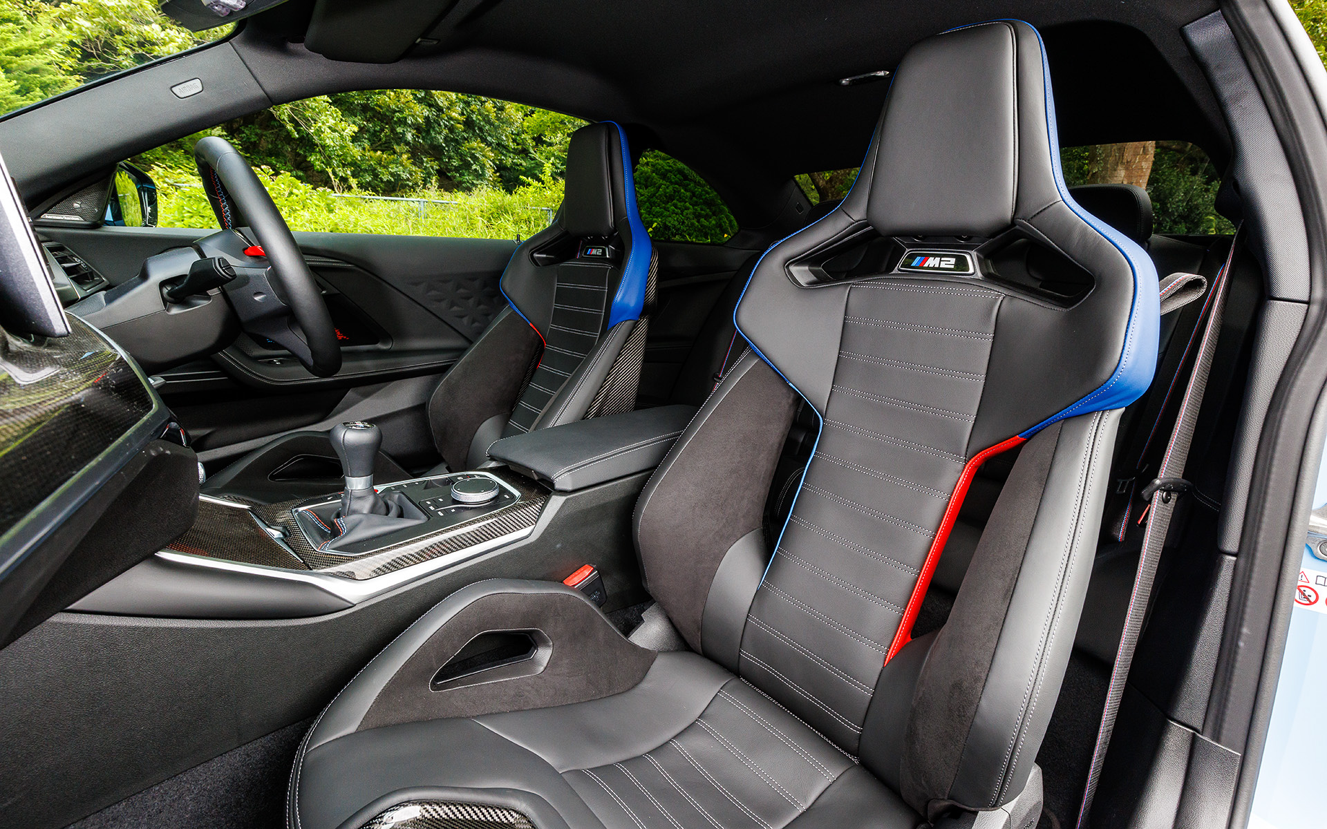 インテリアでは上級モデルの「M3」「M4」と共通のコンポーネントを多く採用し、iドライブ・コントローラー、タッチ操作が可能な視認性に優れたカーブド・ディスプレイなどを装備。サーキット走行に適した「Mカーボン・バケット・シート」もオプション設定（「M RACE TRACK PACKAGE」に含まれる）し、こちらはベースシートと比べ前席2脚で約10kgの軽量化も実現する