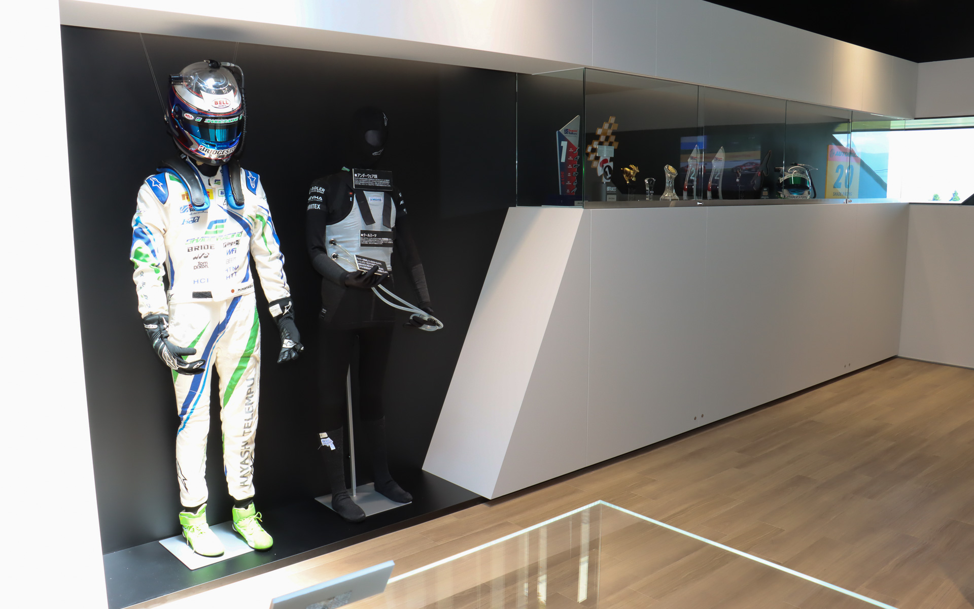 実際のレースで使用されたレーシングスーツやヘルメット、トロフィーなどの展示